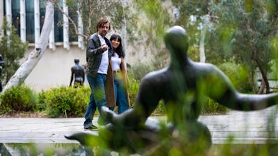 A couple walking through a sculpture garden