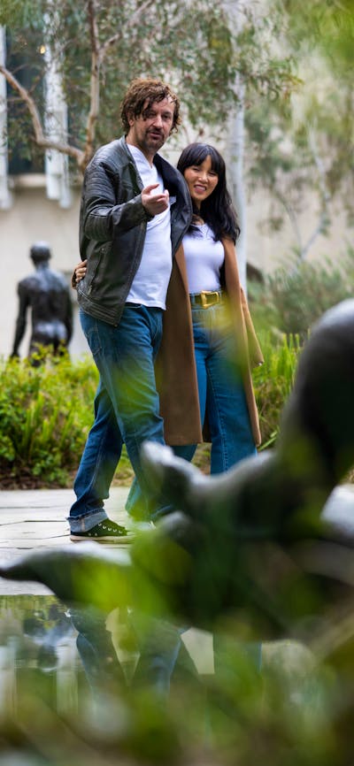 A couple walking through a sculpture garden