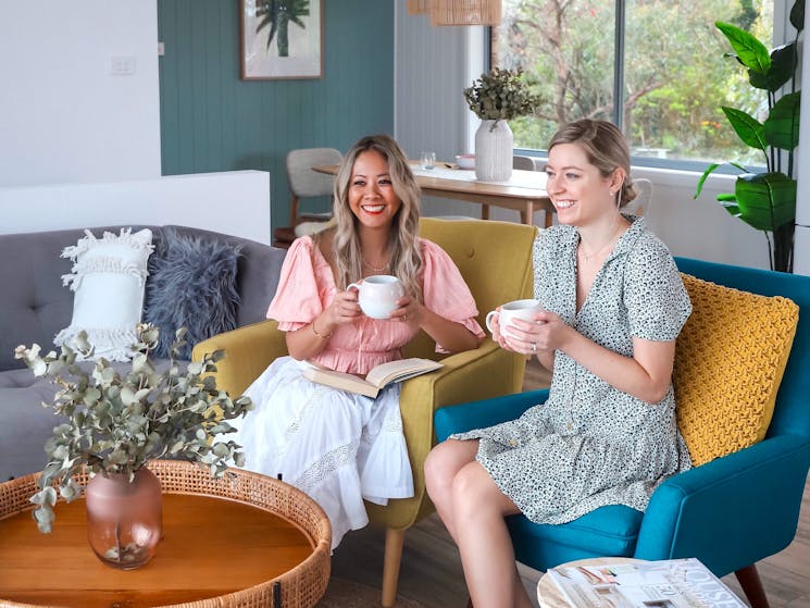 Two ladies enjoy a coffee in the living room of Silvermere Coastal Retreat South Coast NSW