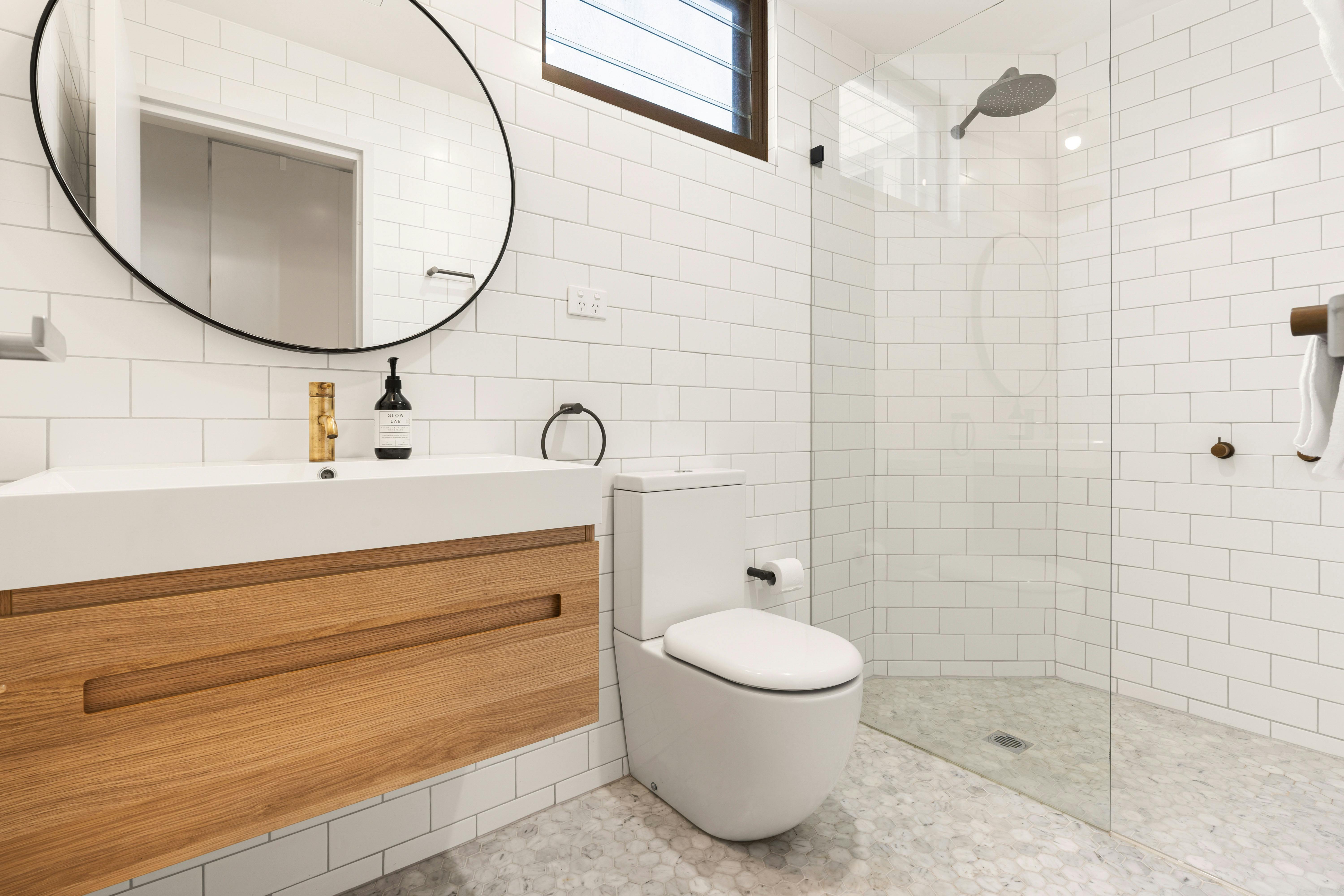 現代浴室配有步入式淋浴間和時尚的木質梳妝台。