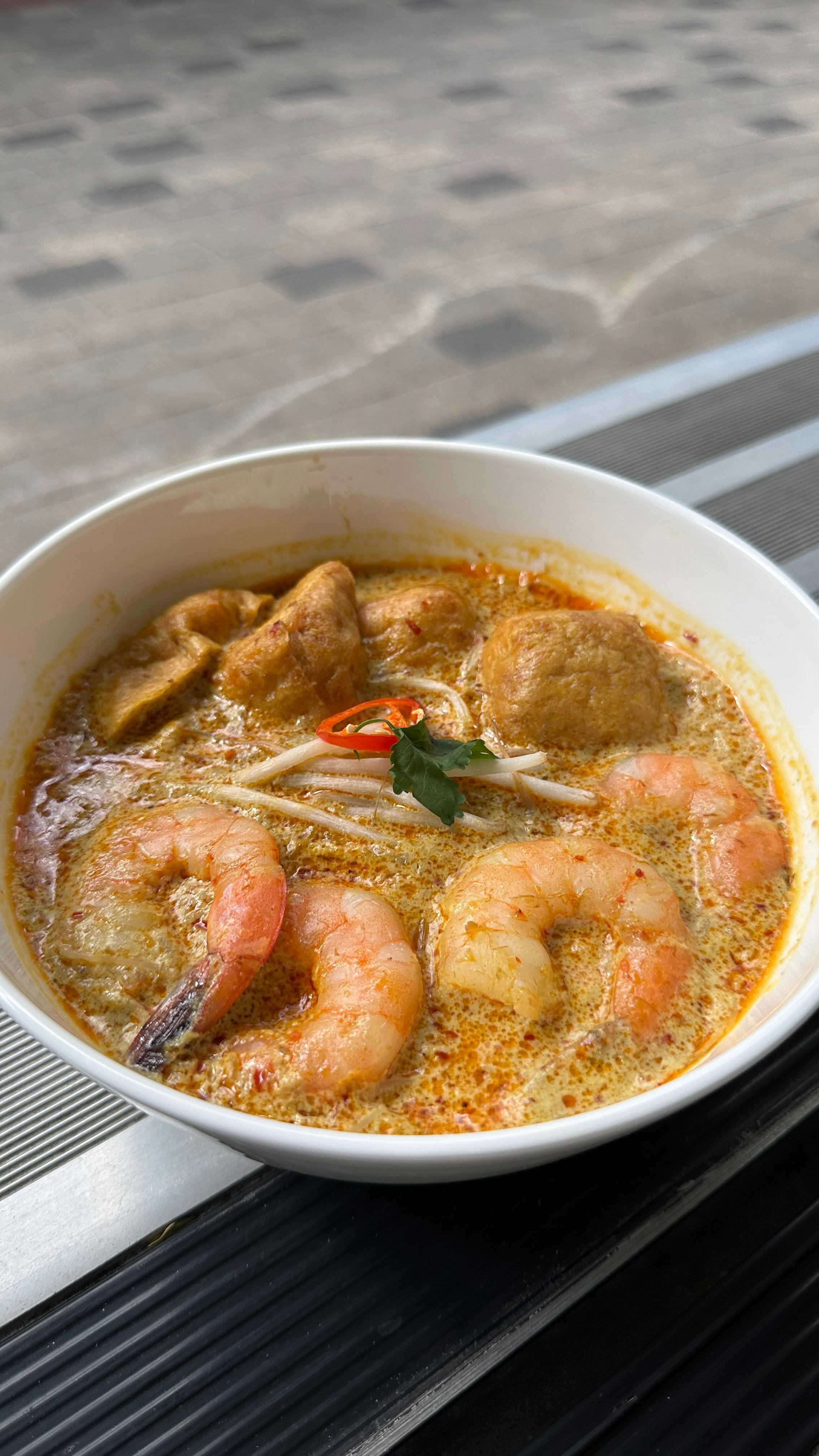 Singapore laksa: creamy coconut curry broth with prawns, fishcakes, tofu puffs, beansprouts & chilli