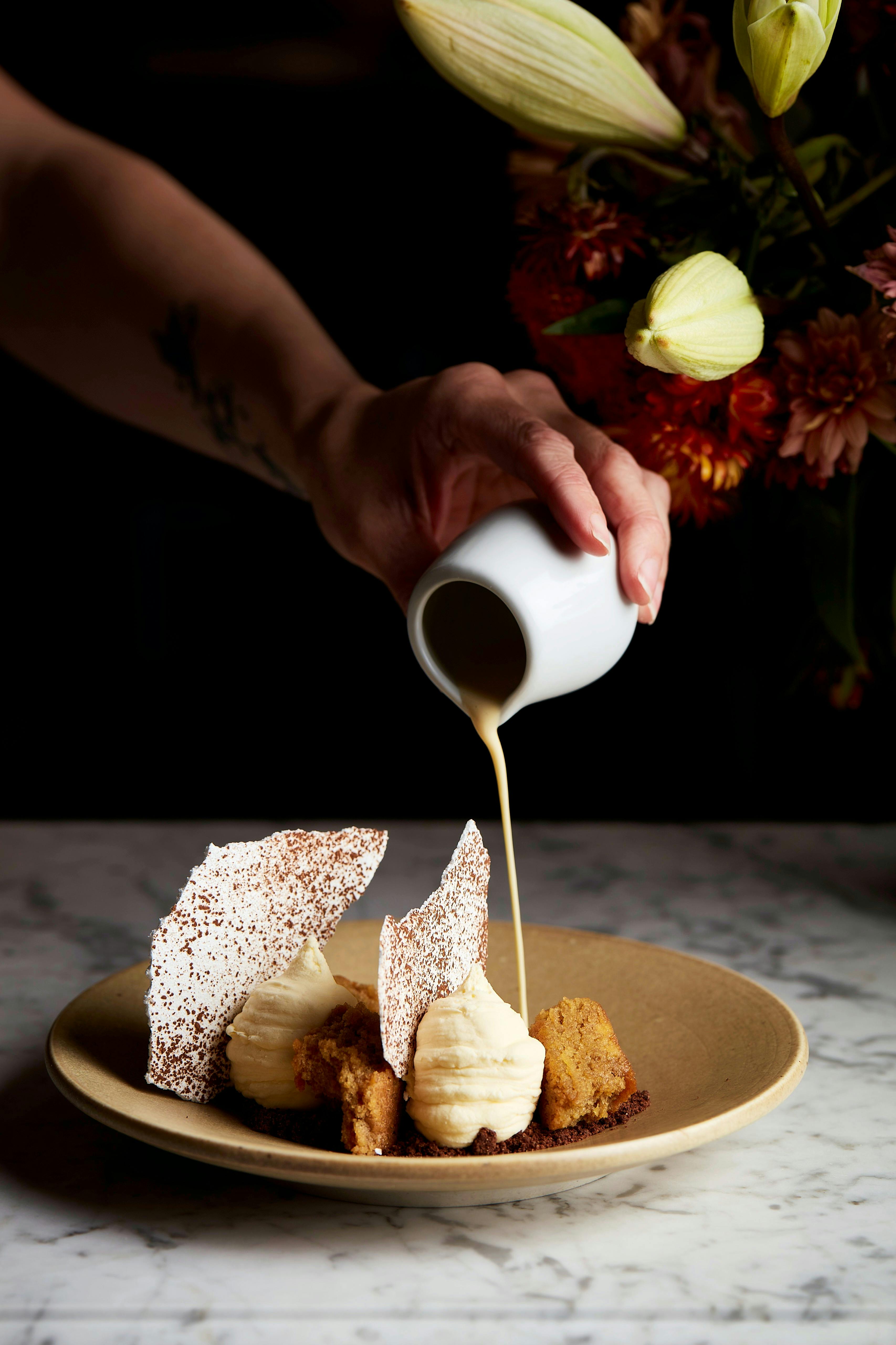 Pouring cream over tiramisu