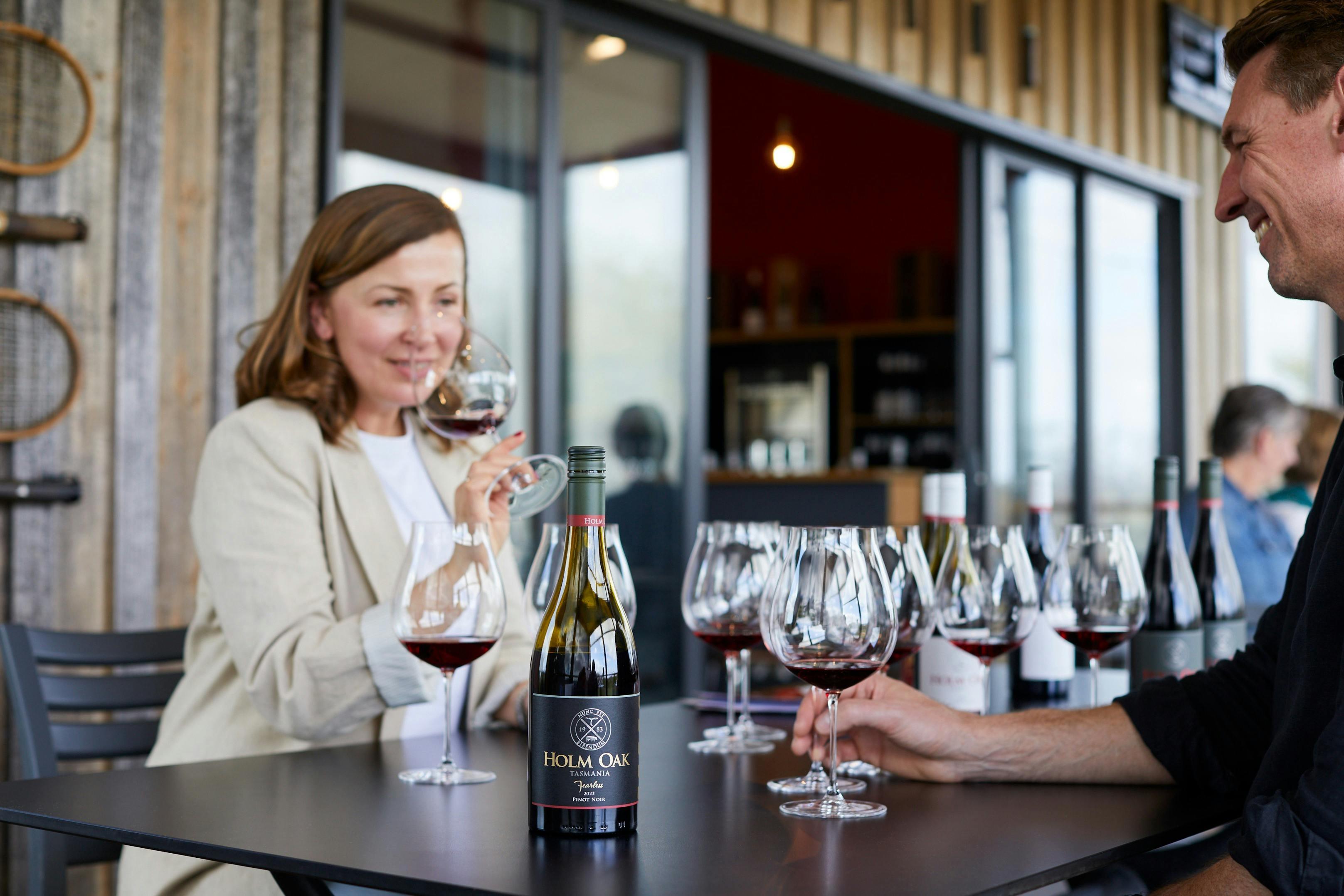 A lady sitting ata table smelling a class of Pinot Noir