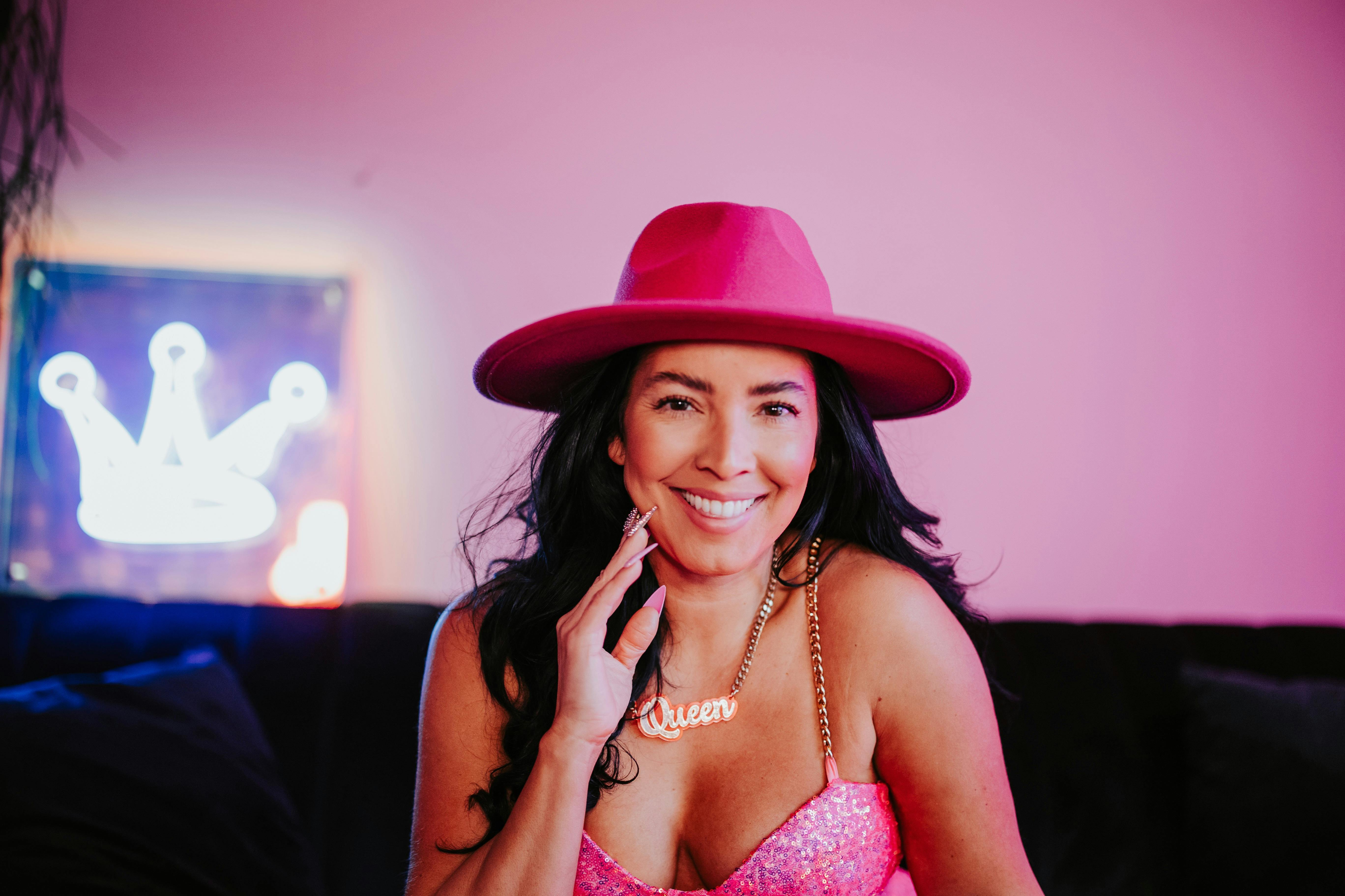 Smiling woman with long black hair wearing pink hat