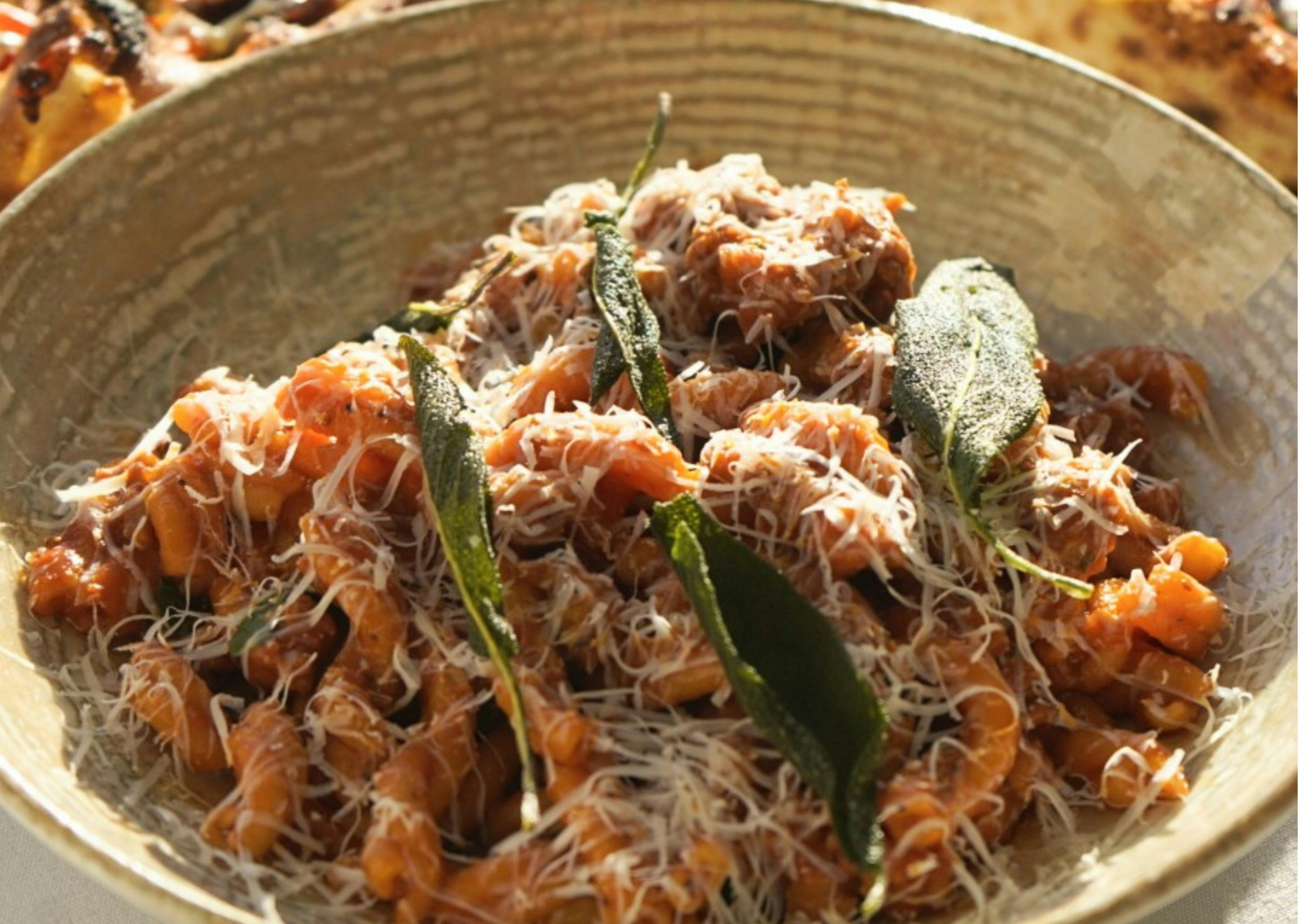 A bowl of ragu pasta with parmesan cheese