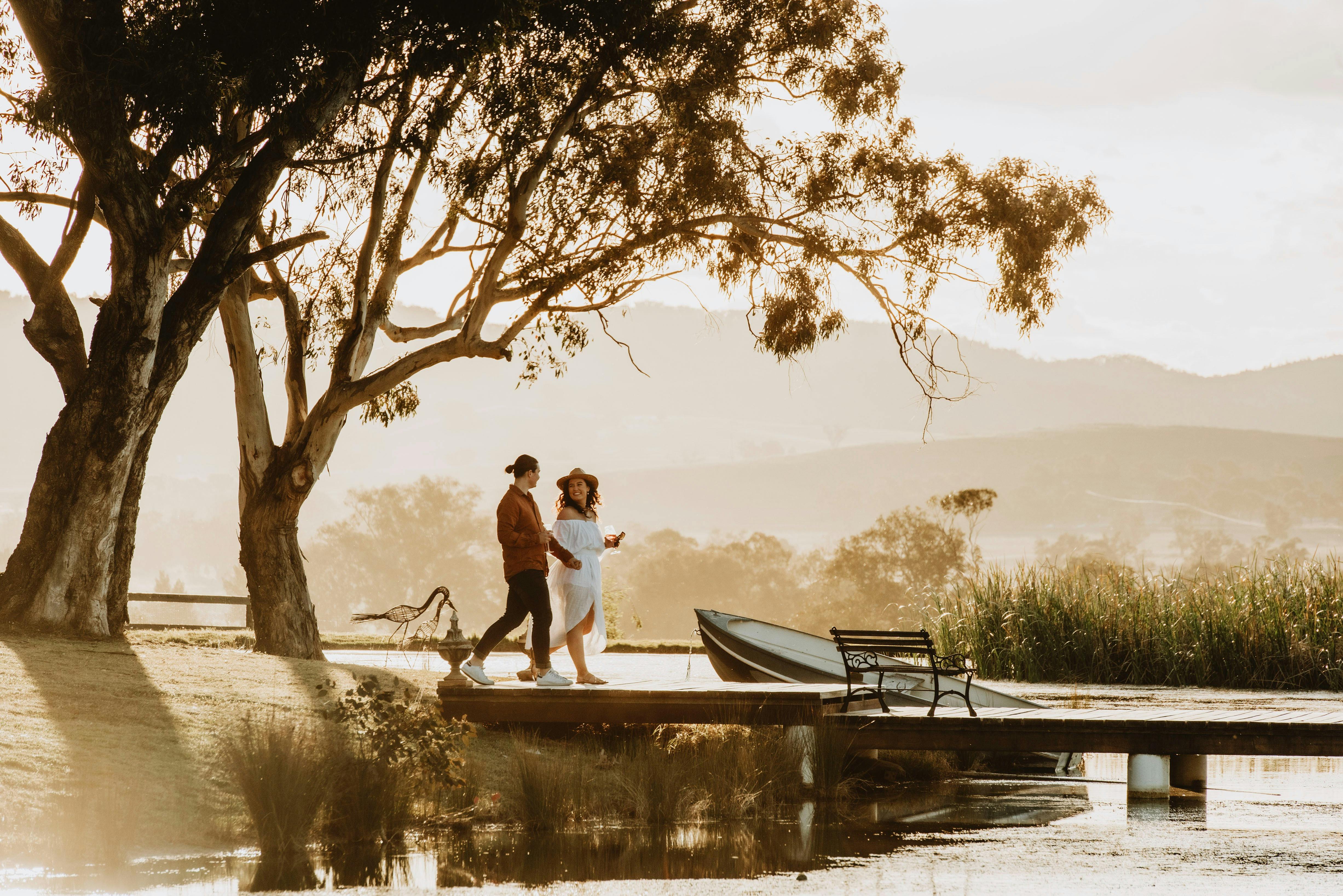 Sunset filtered sunset light, couple walking along the jetty stunning evening views