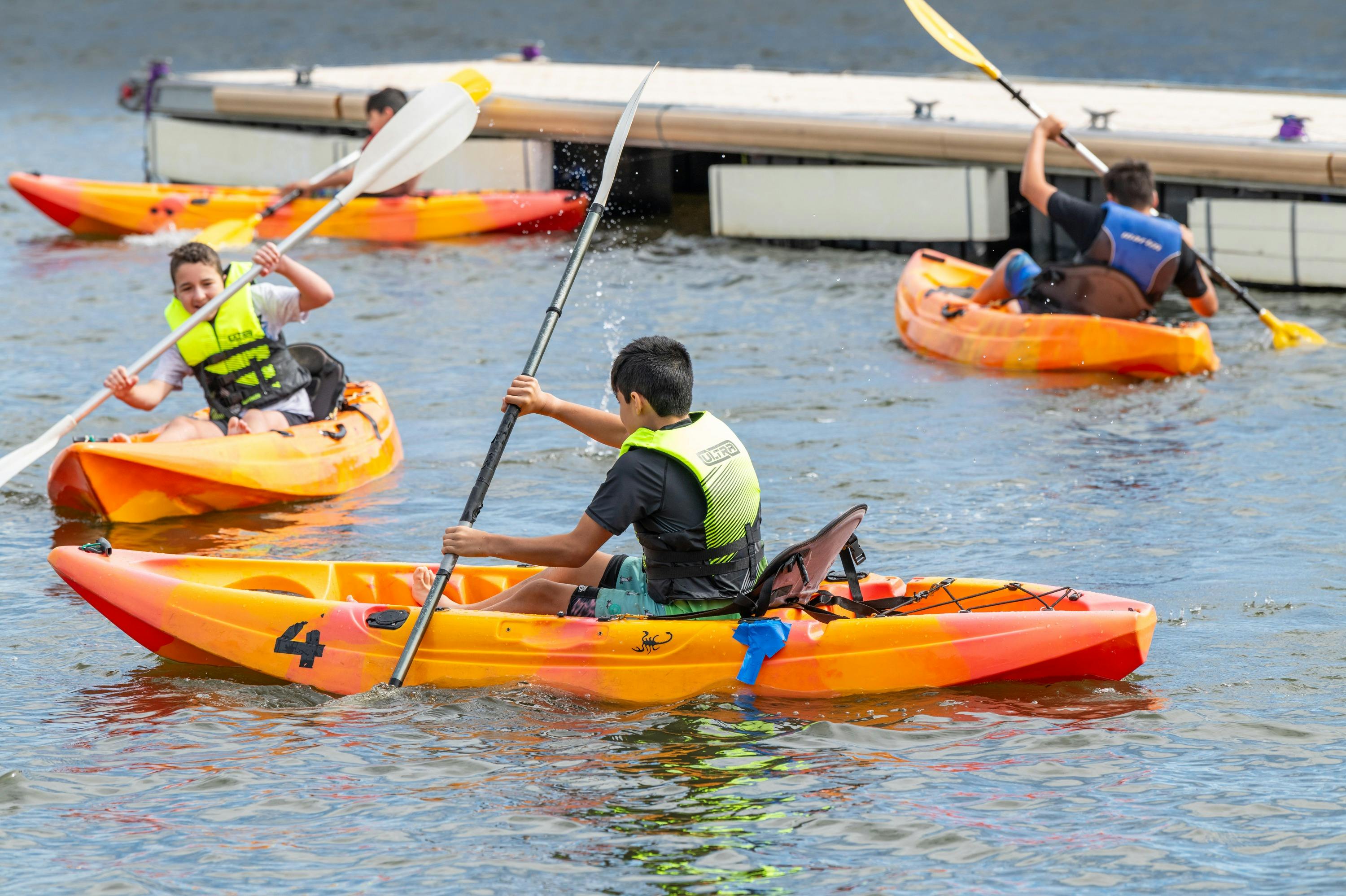 3 Youth on Single Kayaks in water