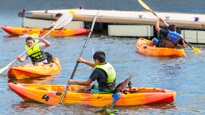 3 Youth on Single Kayaks in water
