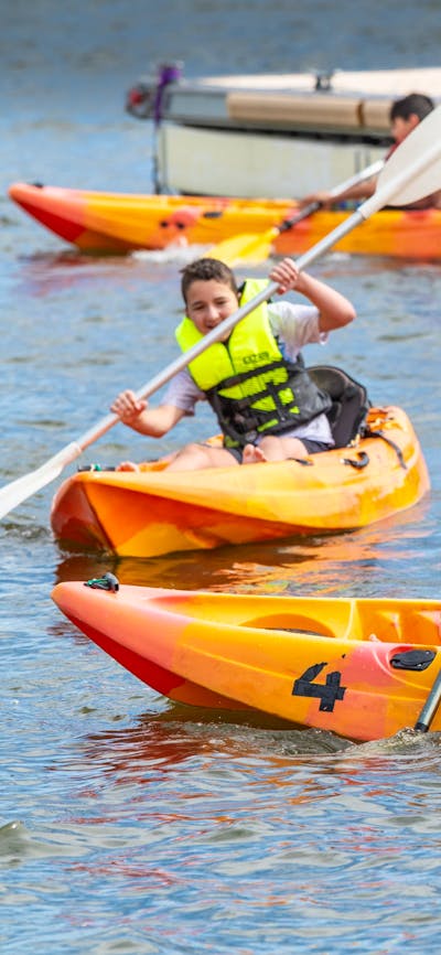 3 Youth on Single Kayaks in water