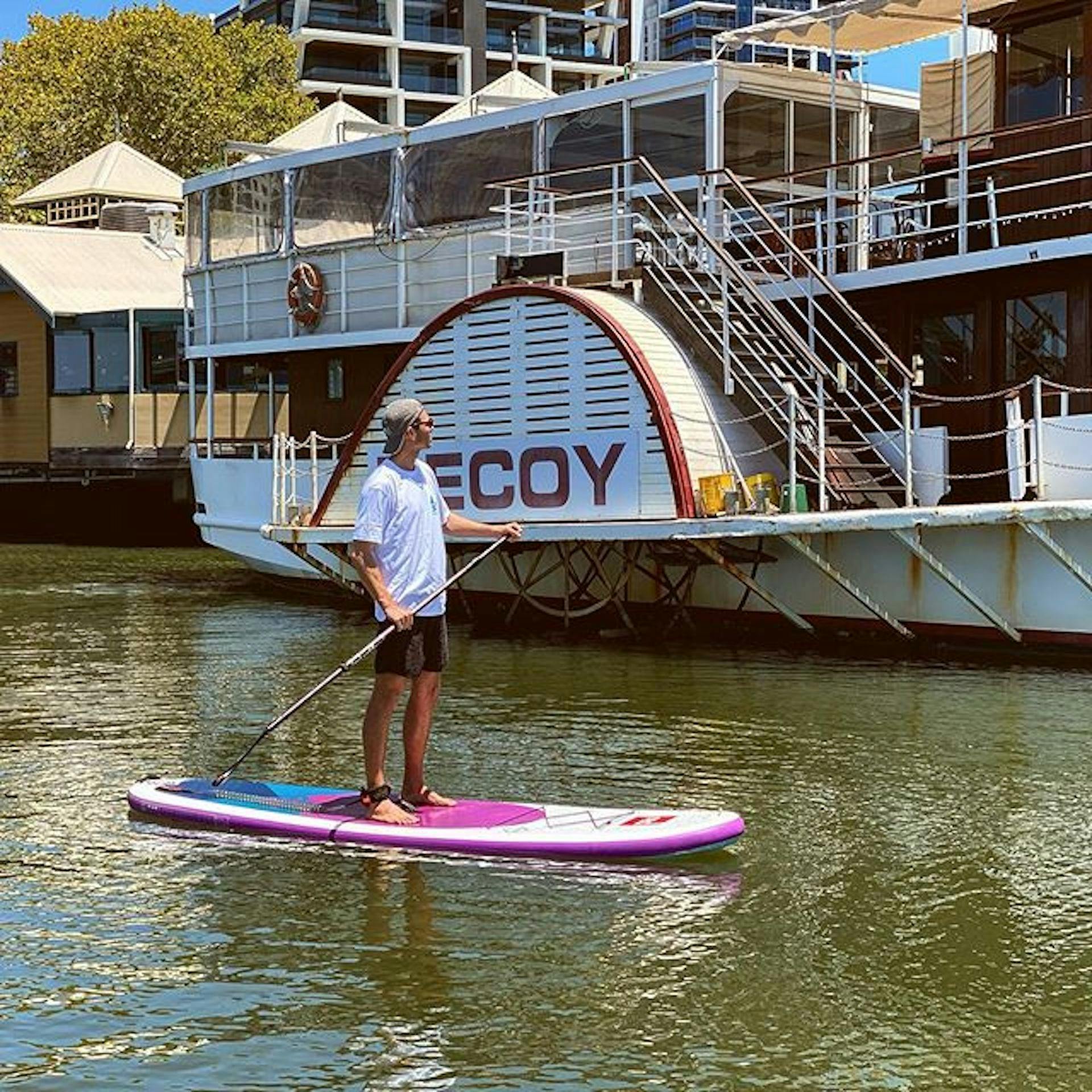 A paddle boarder enjoying the calm waters of the Swan River, near Mend's  Street Jetty  South  Perth