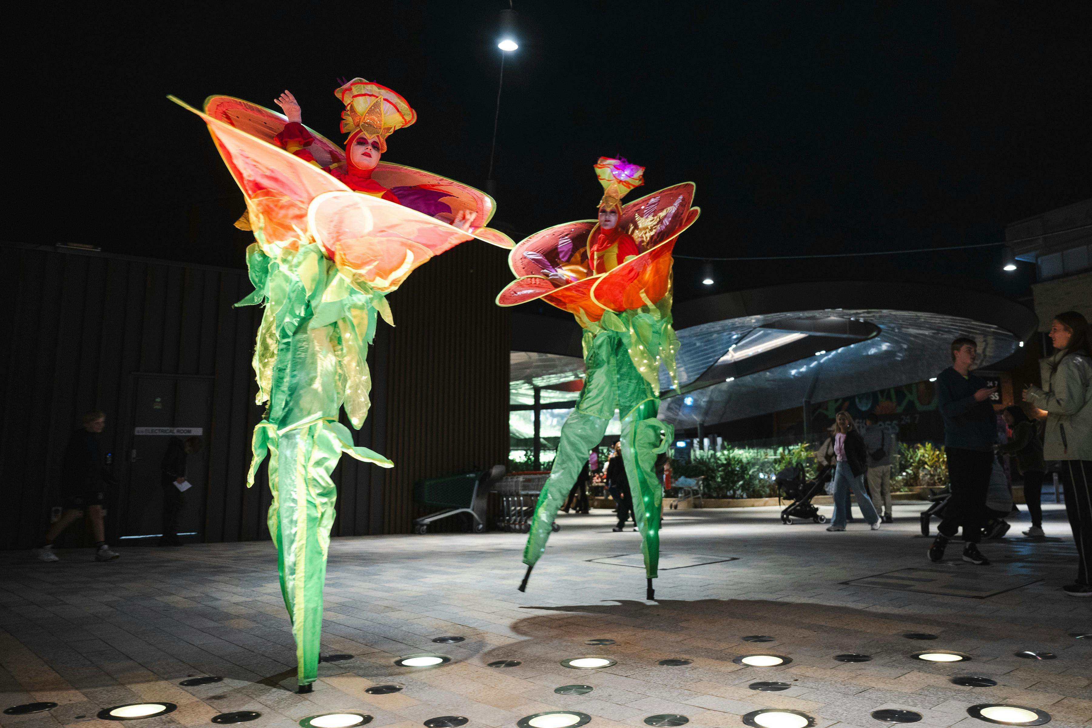 Roving performers on stilts dressed as giant flowers