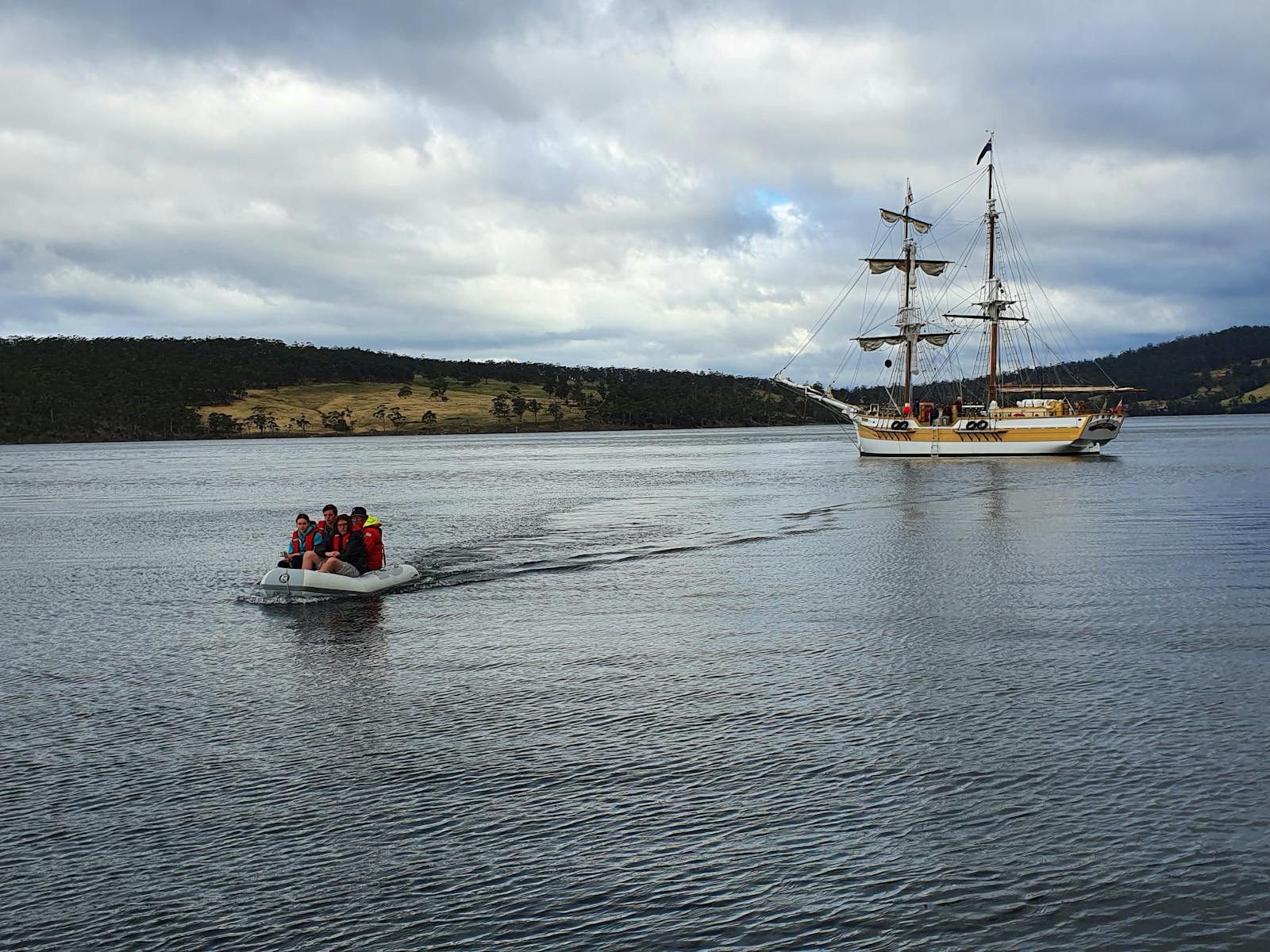 The Lady Nelson is anchored in the background the tender is taking the passengers to the hidden bay