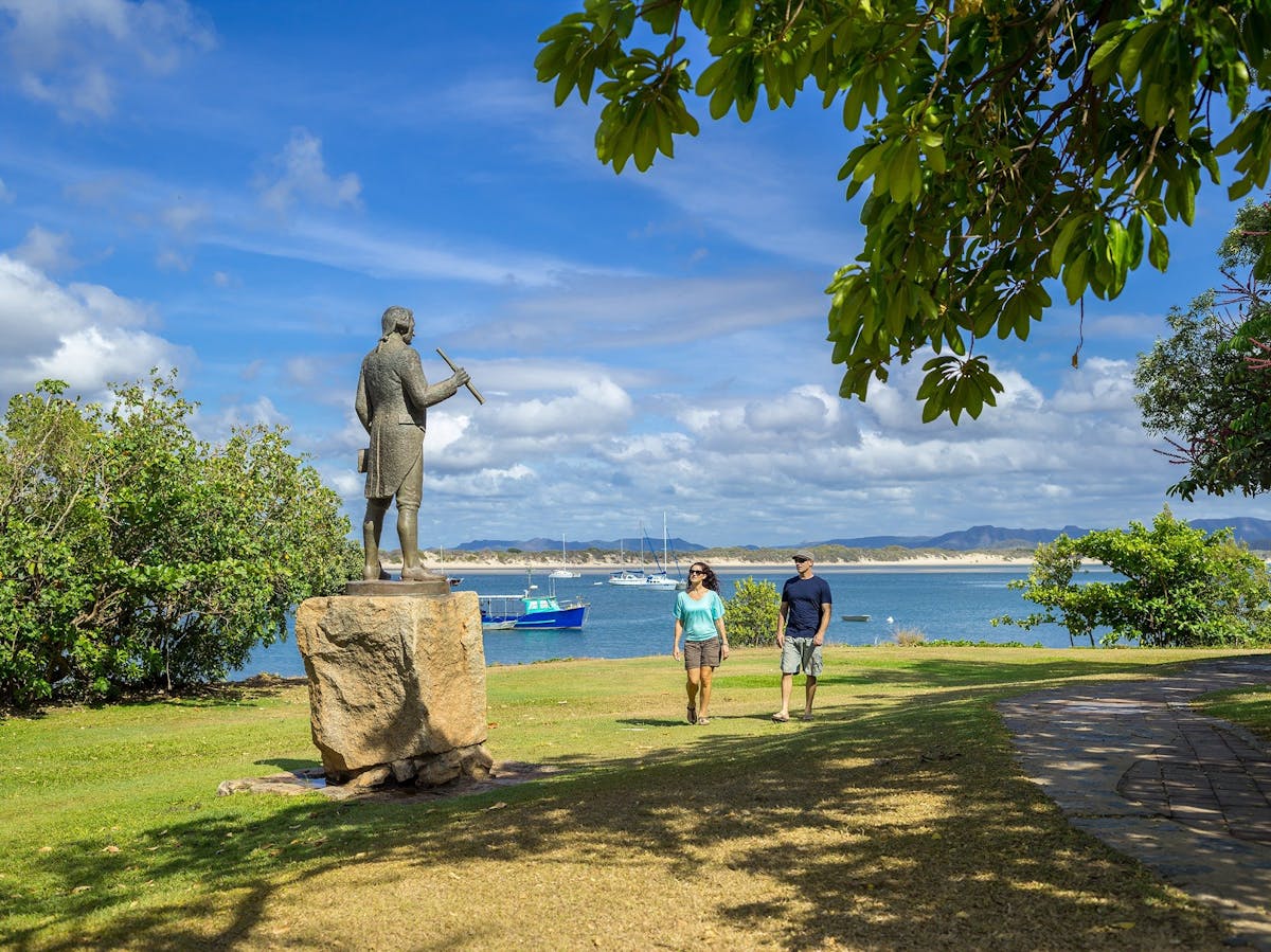 Captain Cook statue and Cooktown foreshore with guests walking along the grass.