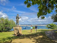 Captain Cook statue and Cooktown foreshore with guests walking along the grass.