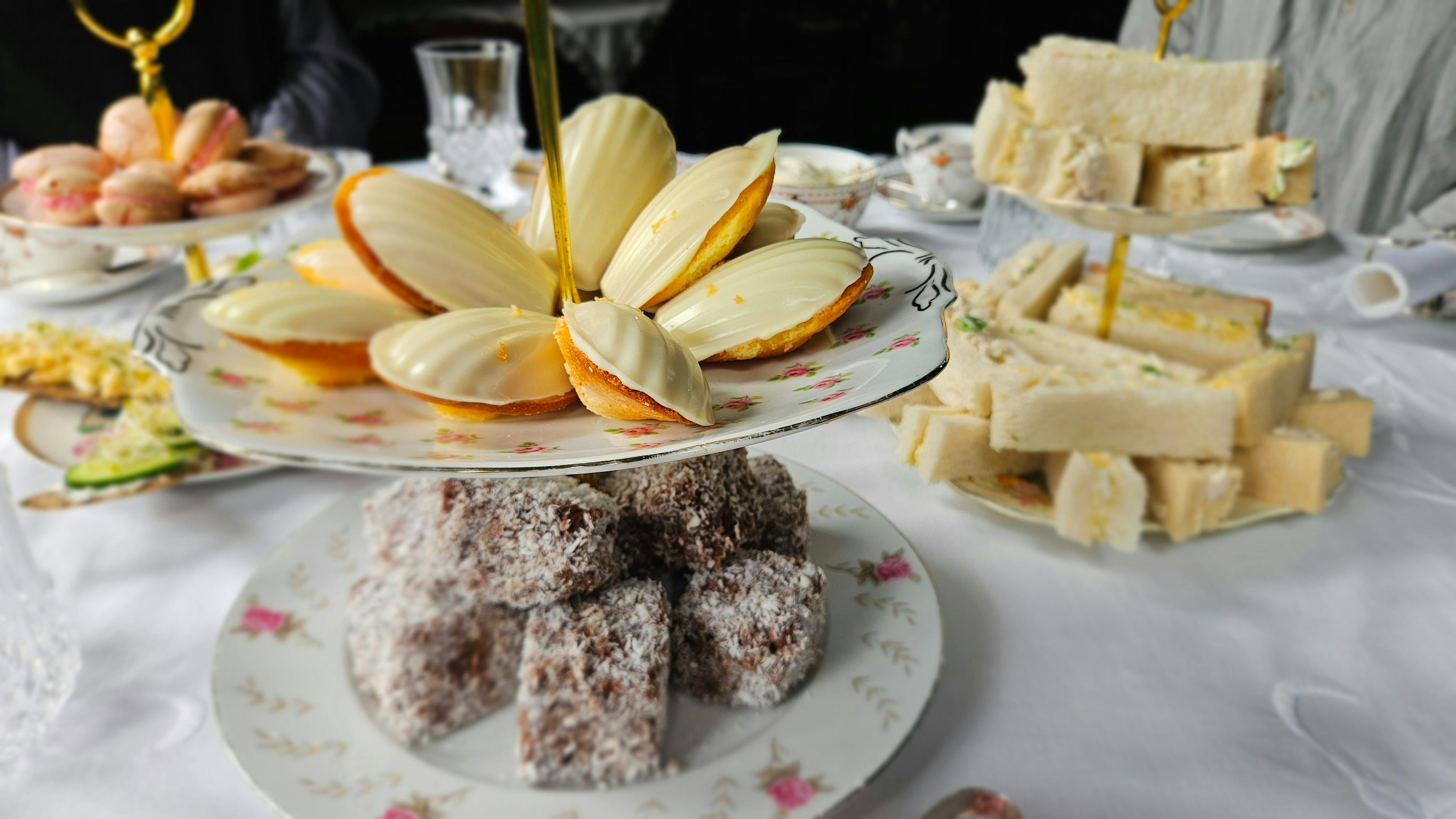 Tiered stand of madeleines and coconut lamingtons with finger sandwiches, Yallum Park high tea