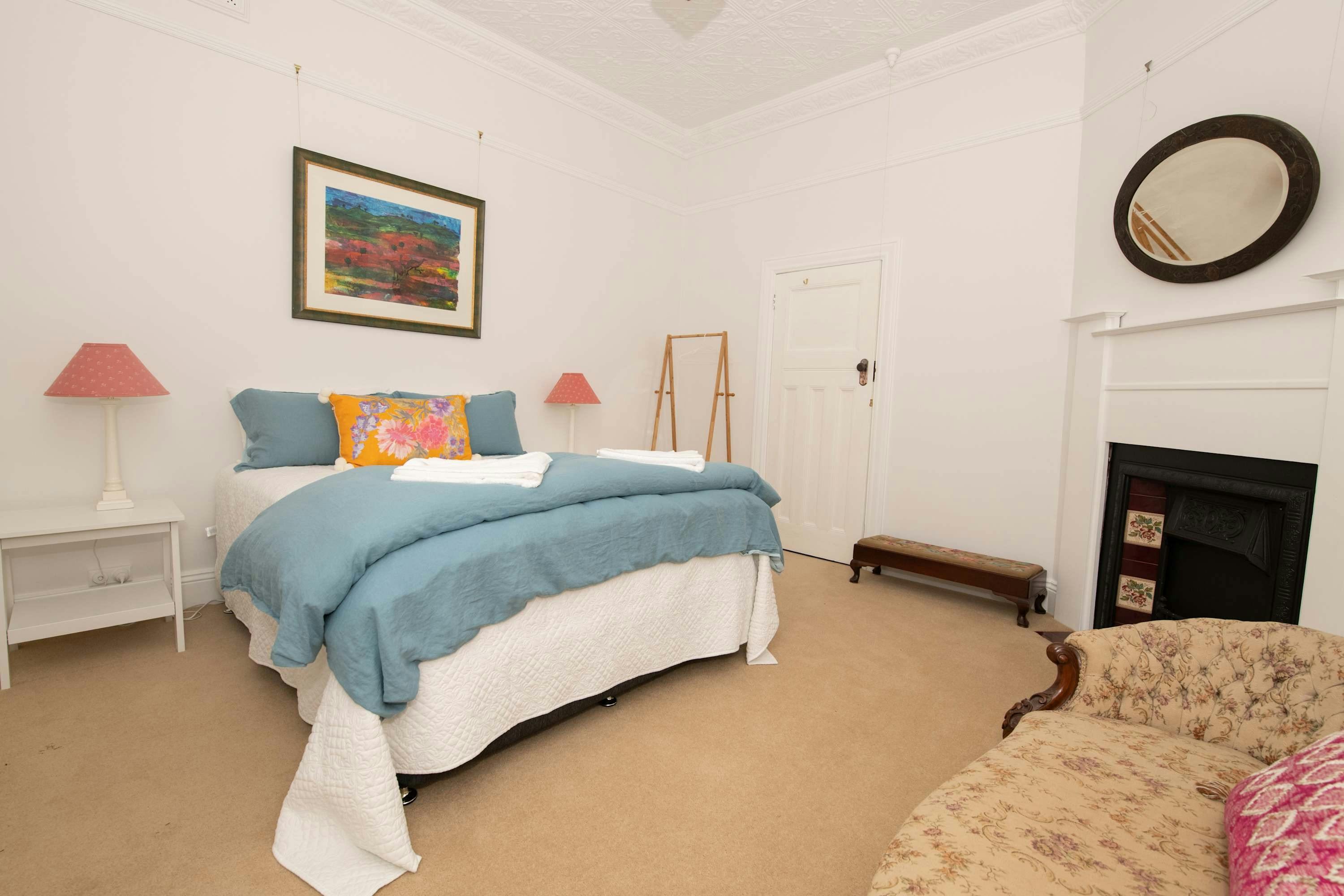 파란색 침구 카펫 나무 난로가 있는 침실