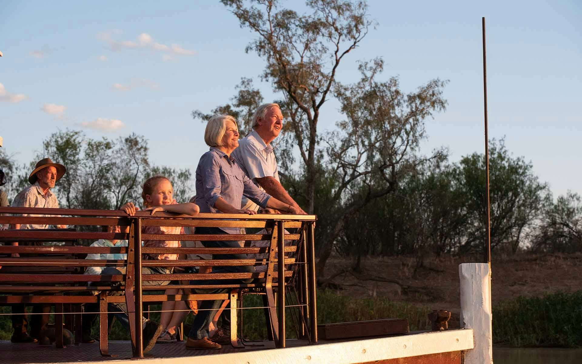 Two guests watching the sunset fromthe edge of the Thomson Belle