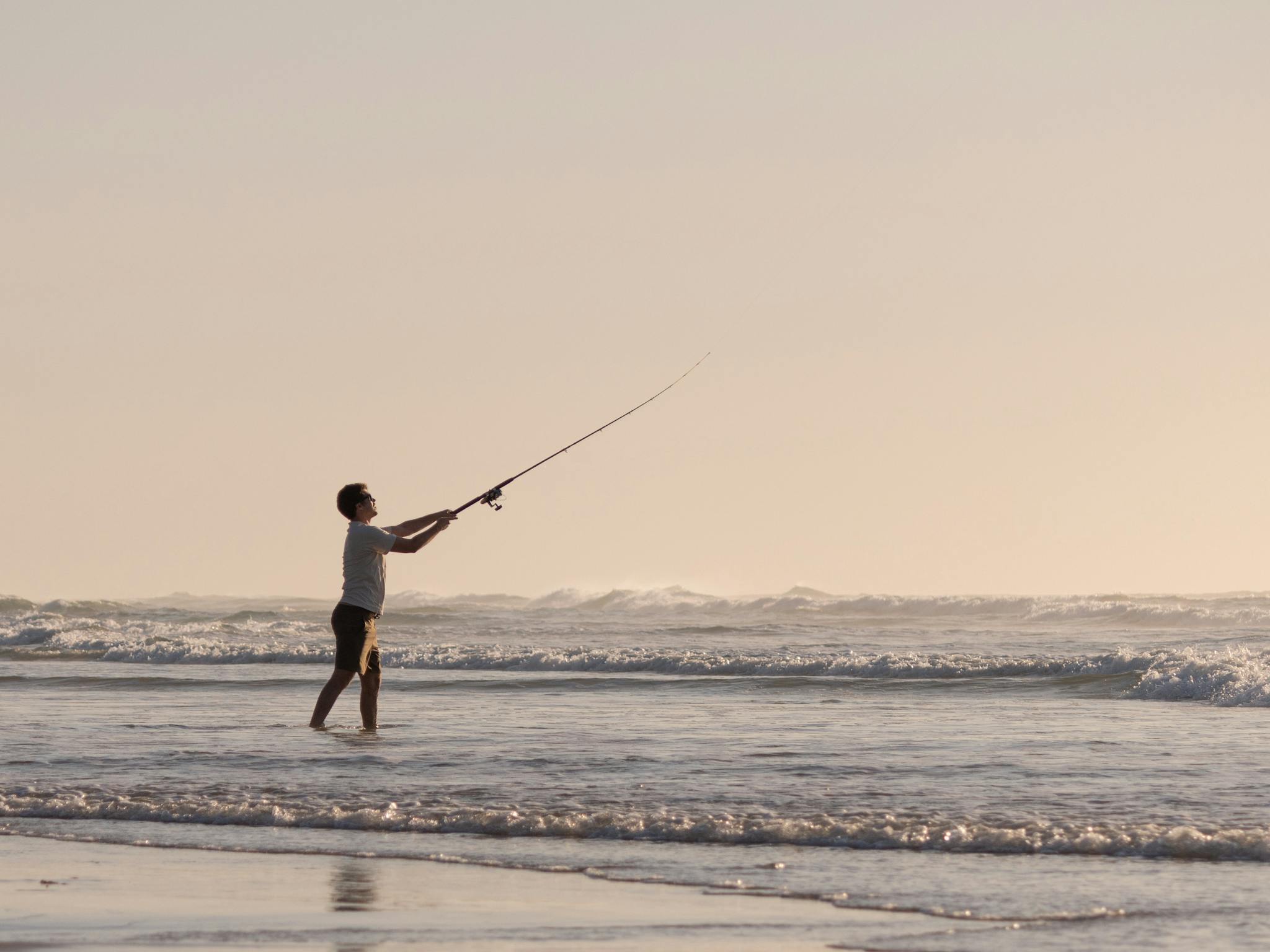 lifestyle shot of a man fishing at the beach