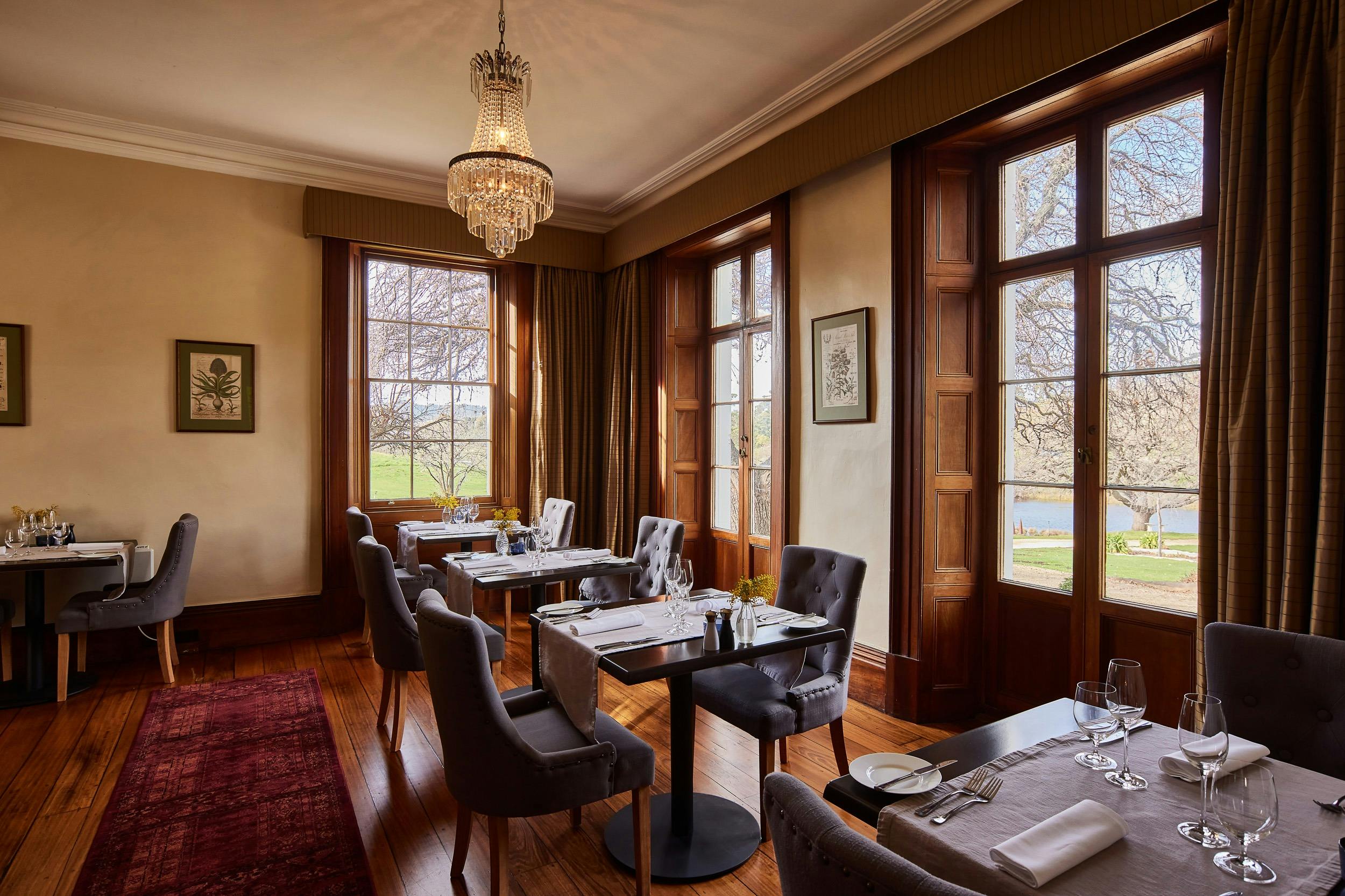 Dining room pictured in natural with floor to ceiling windows. Exposed wood is the main character.
