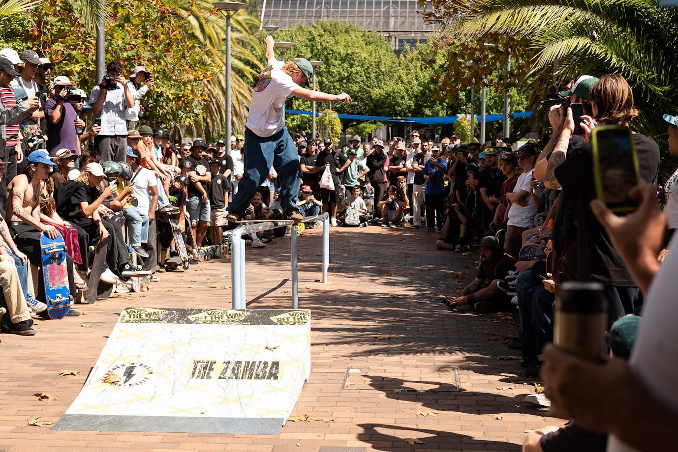 Skateboarder performs Backside Lipslide in front of crowd at Belconnen