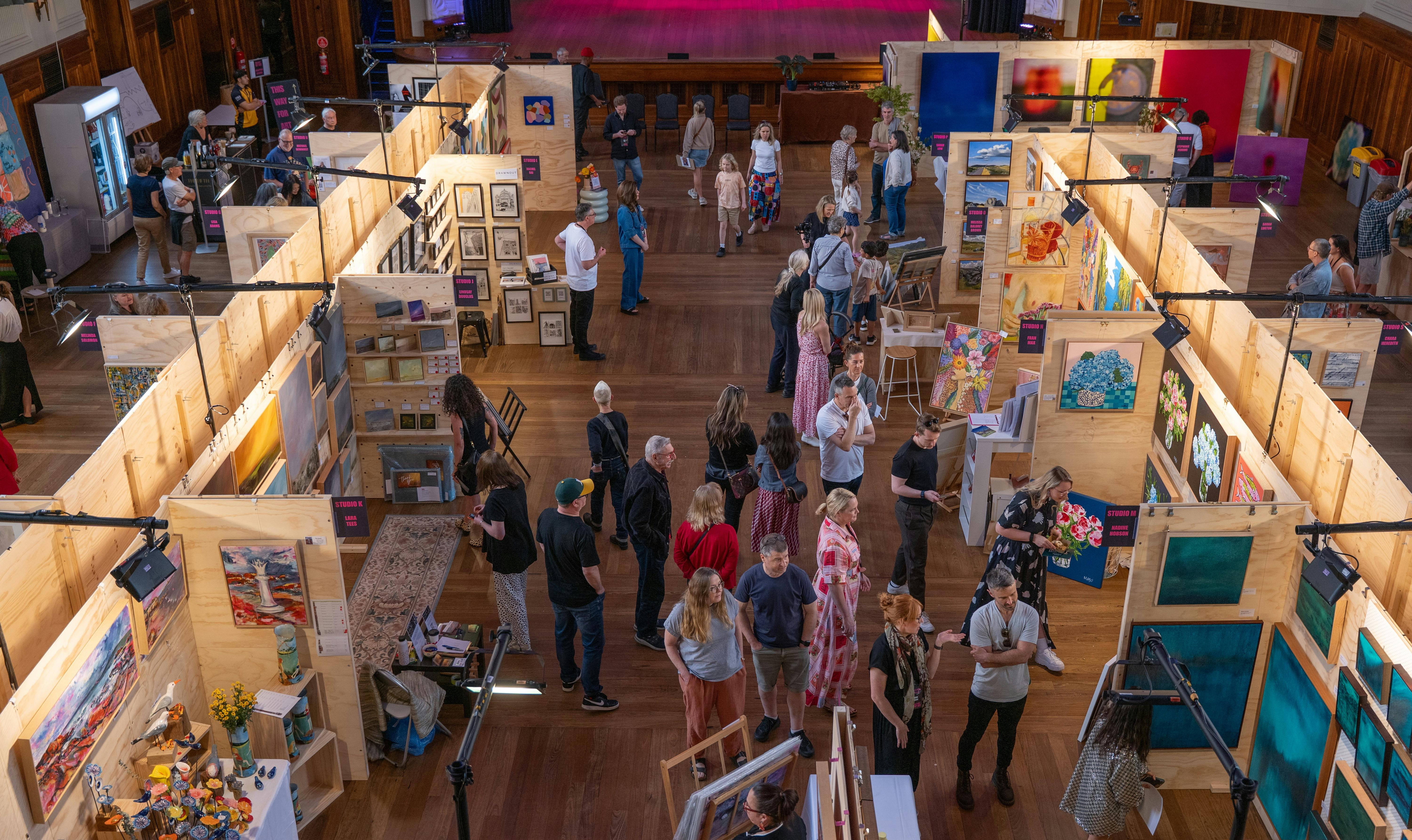 People gathered around Inner West Art Fair looking and engaging with he art whilst talking