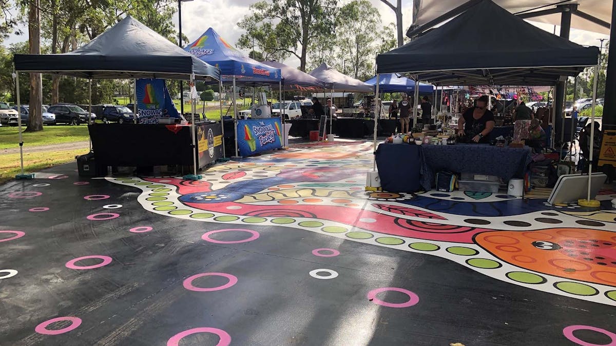 Market stalls on colourful plaza artwork