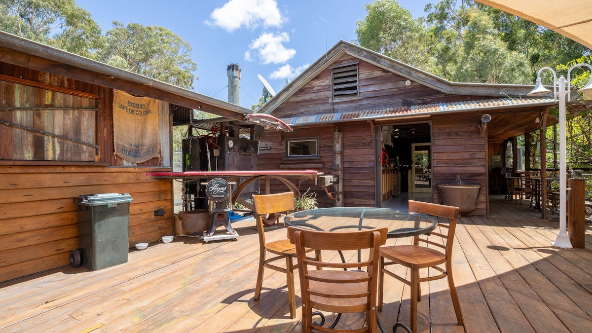 balcony seating with schoolhouse cafe in the background and industrial rustic style pizza oven