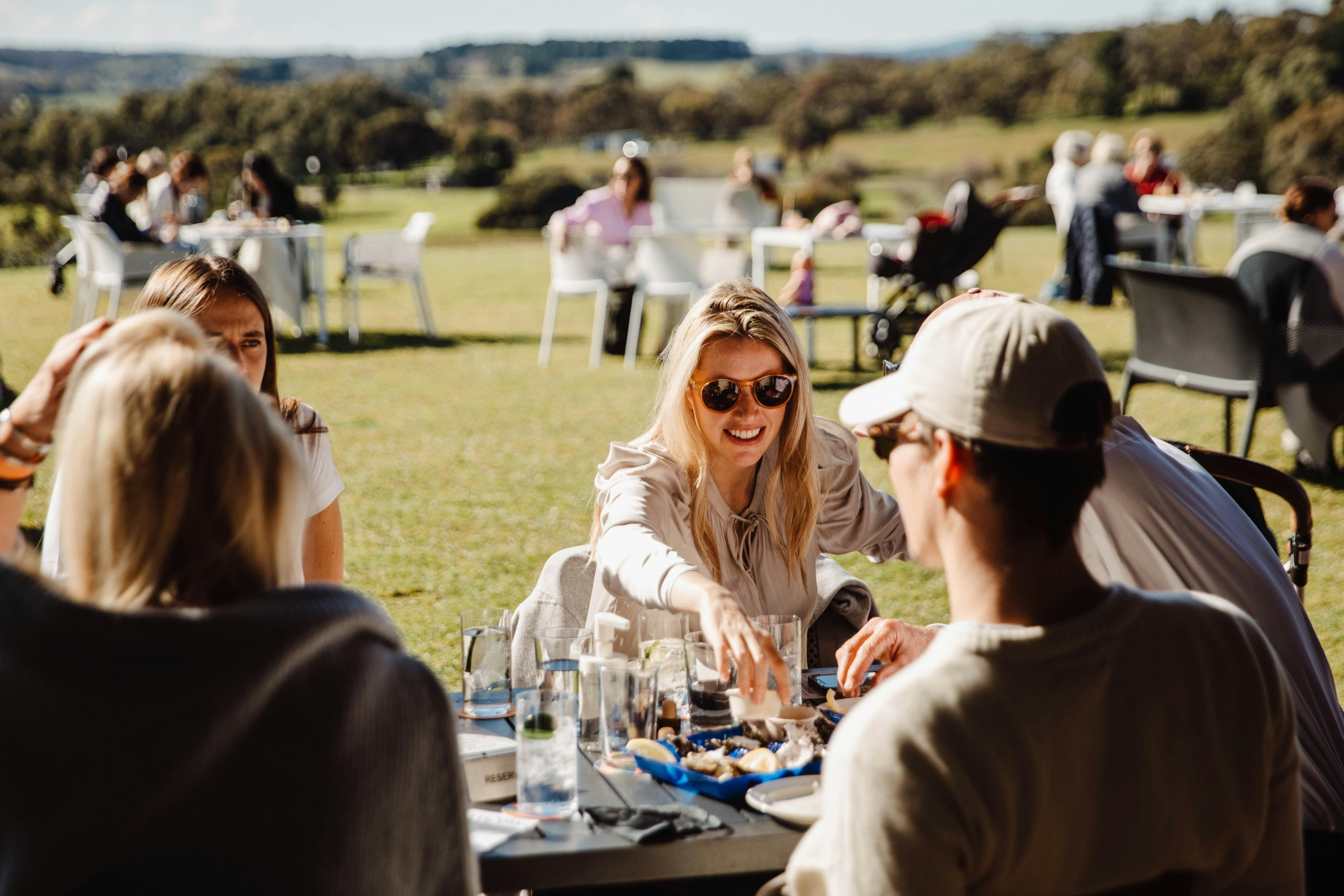 Guests enjoy spring sunshine on the lawns at the Never Never Distillery Door in McLaren Vale