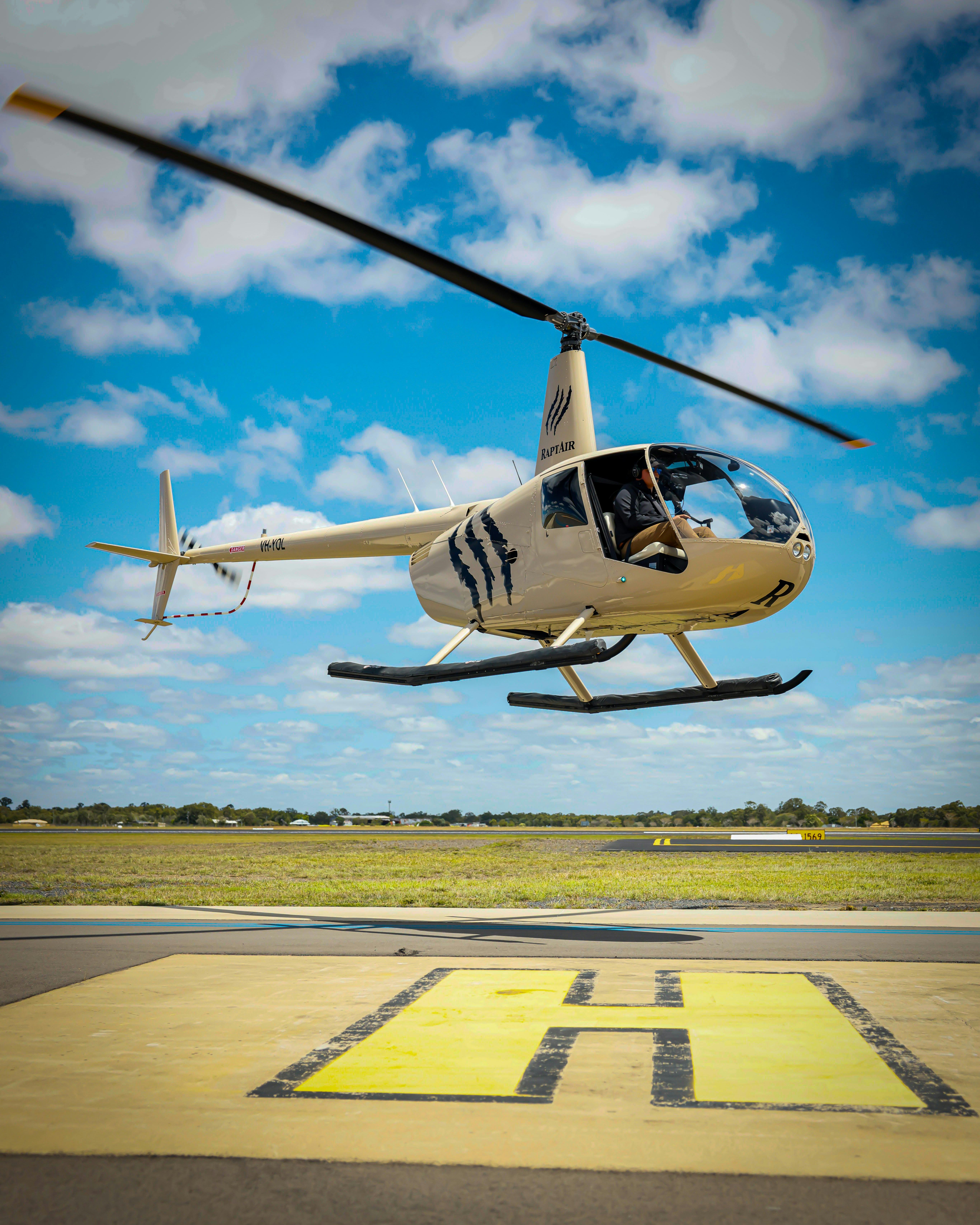Helicopter Take-off from the helipad- the claw logo of RaptAir highlighted against the blue sky