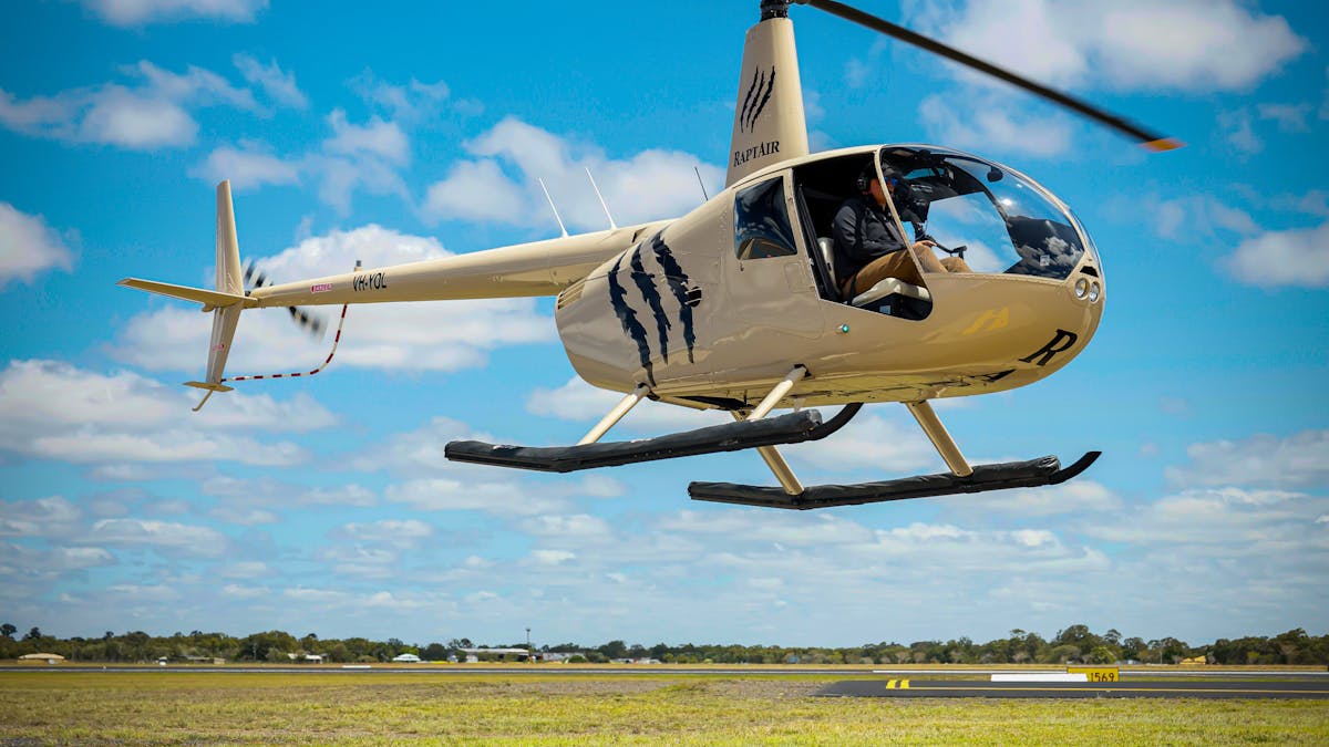 Helicopter Take-off from the helipad- the claw logo of RaptAir highlighted against the blue sky