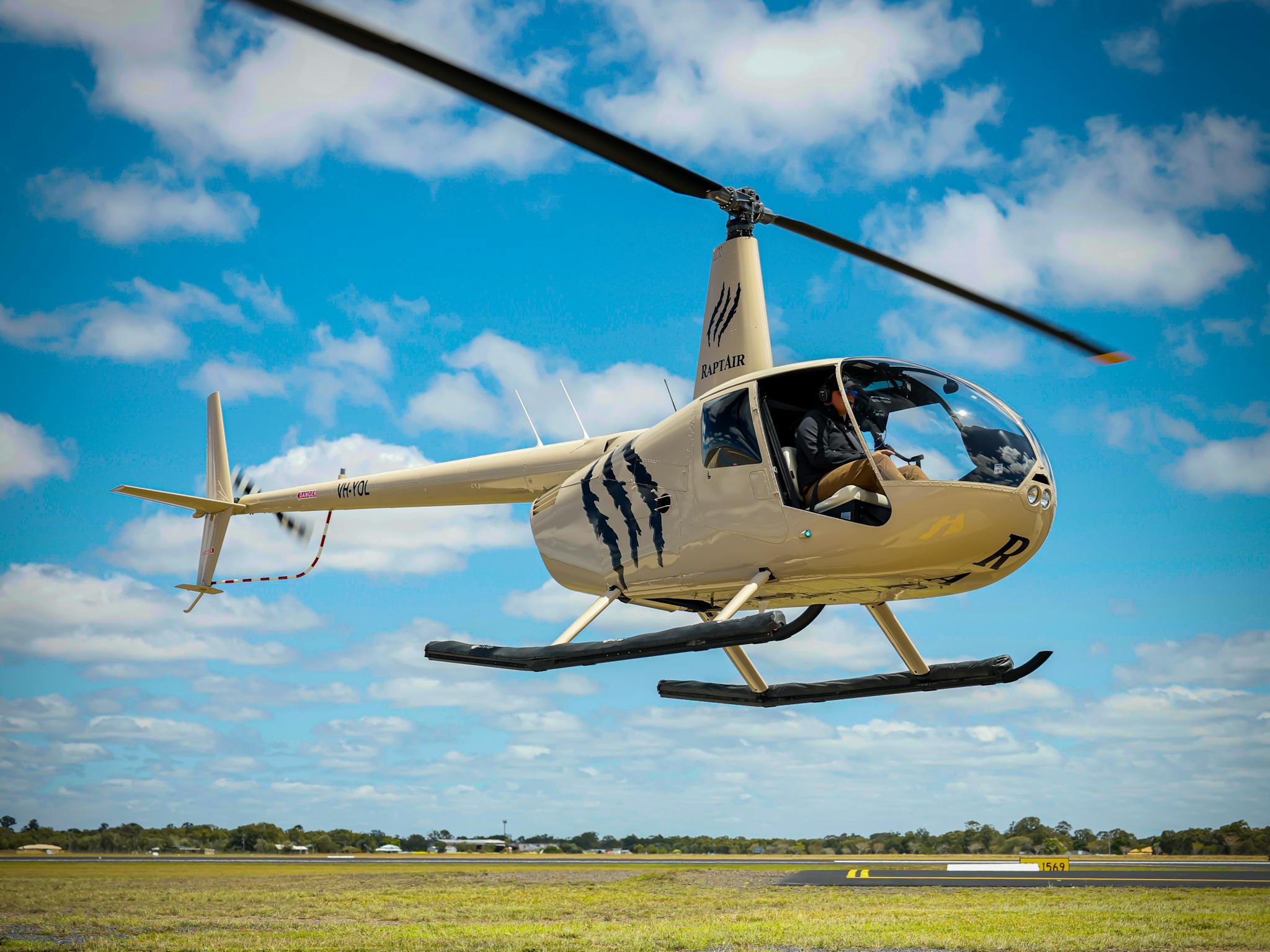 Helicopter Take-off from the helipad- the claw logo of RaptAir highlighted against the blue sky
