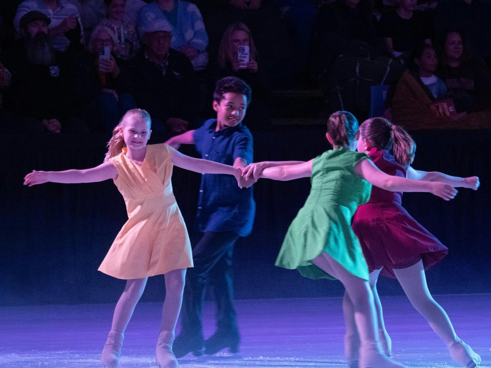 Young figure skaters in multi coloured costumes