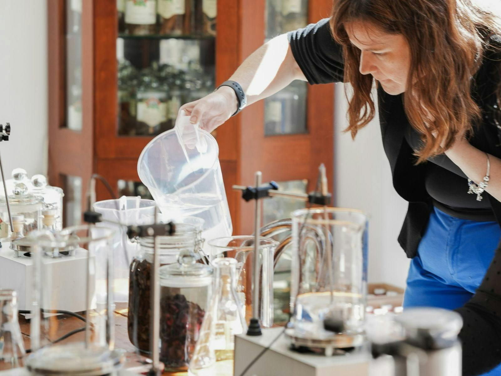 Woman working at a table during the Liqueur making experience.