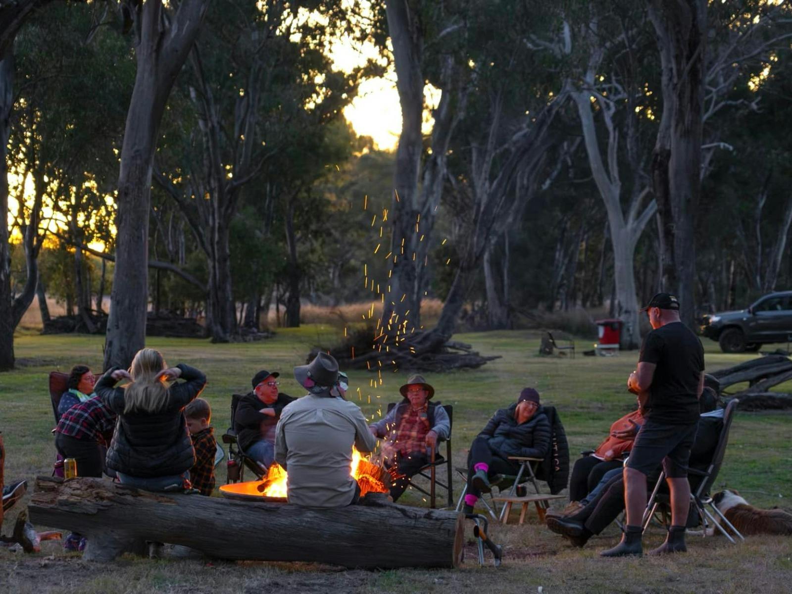 Group of people sitting around campfire at Agora Hideaway