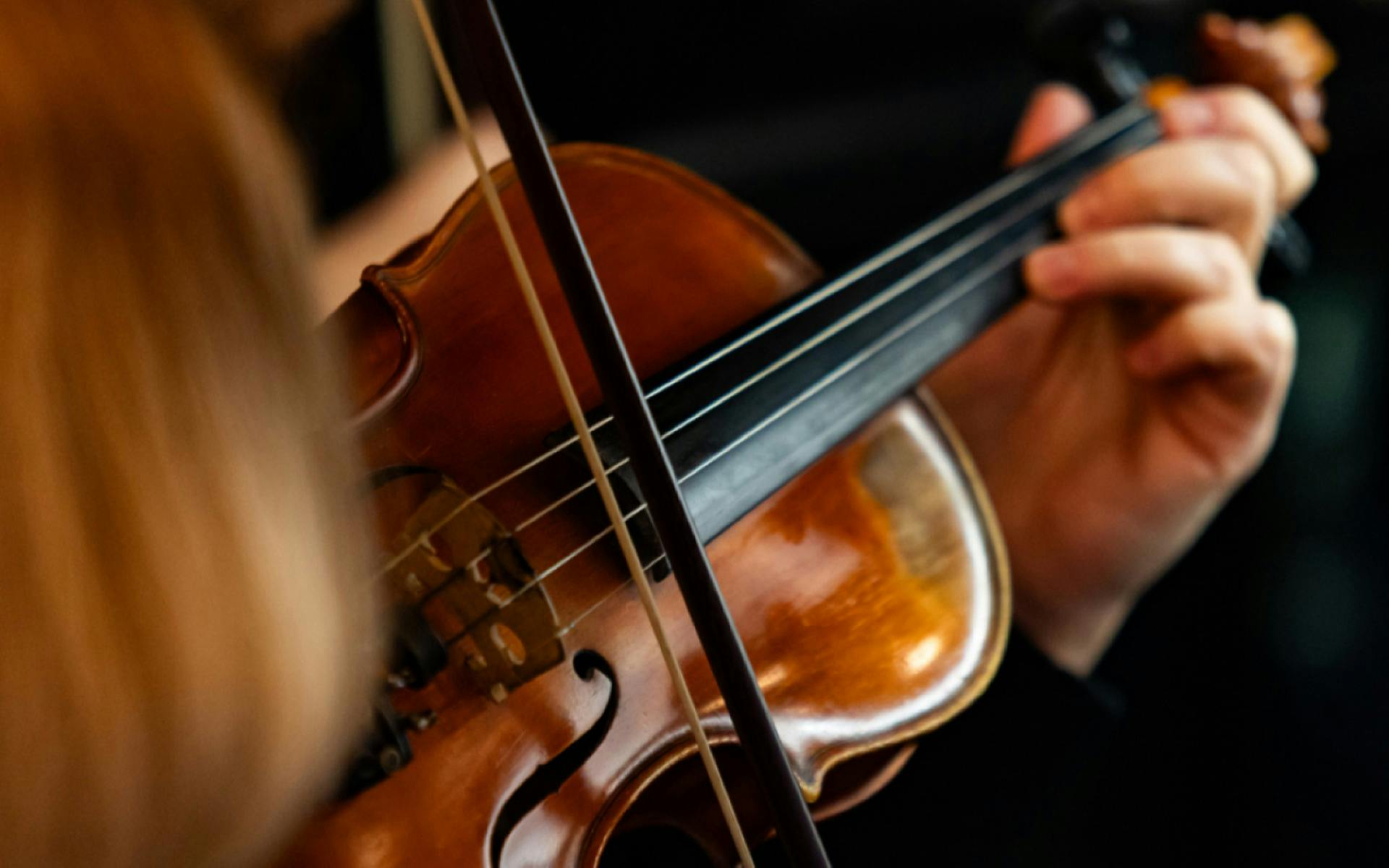 A close up photo of a person playing the violin.
