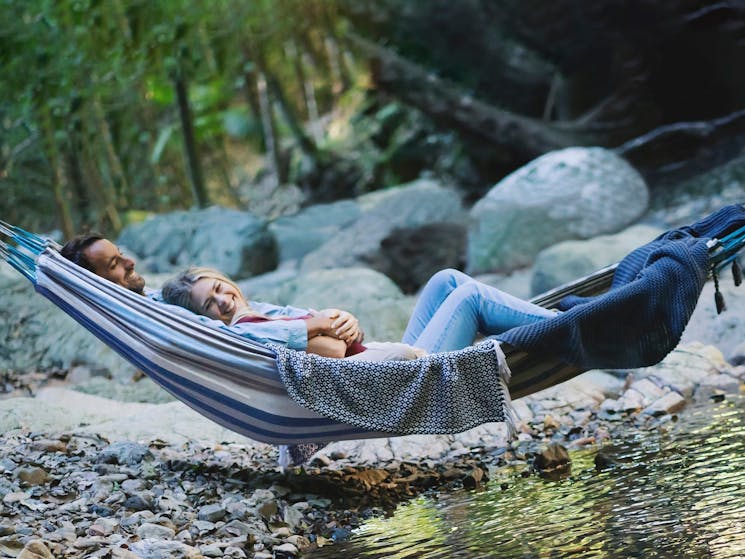 honeymooners happy together in a hammock over crystal creek at the eco luxury resort
