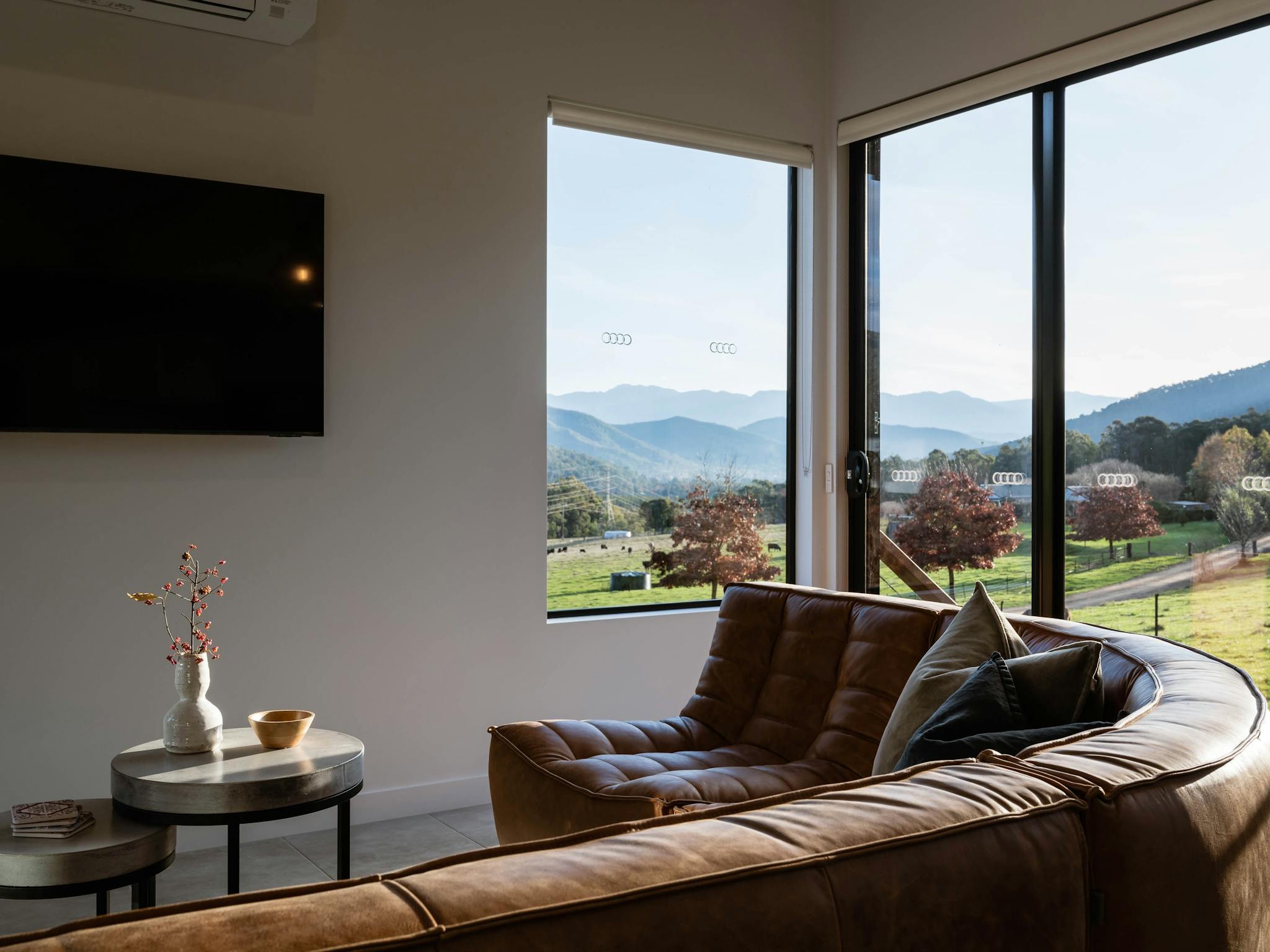 Leather couch looking out of big windows with mountain views