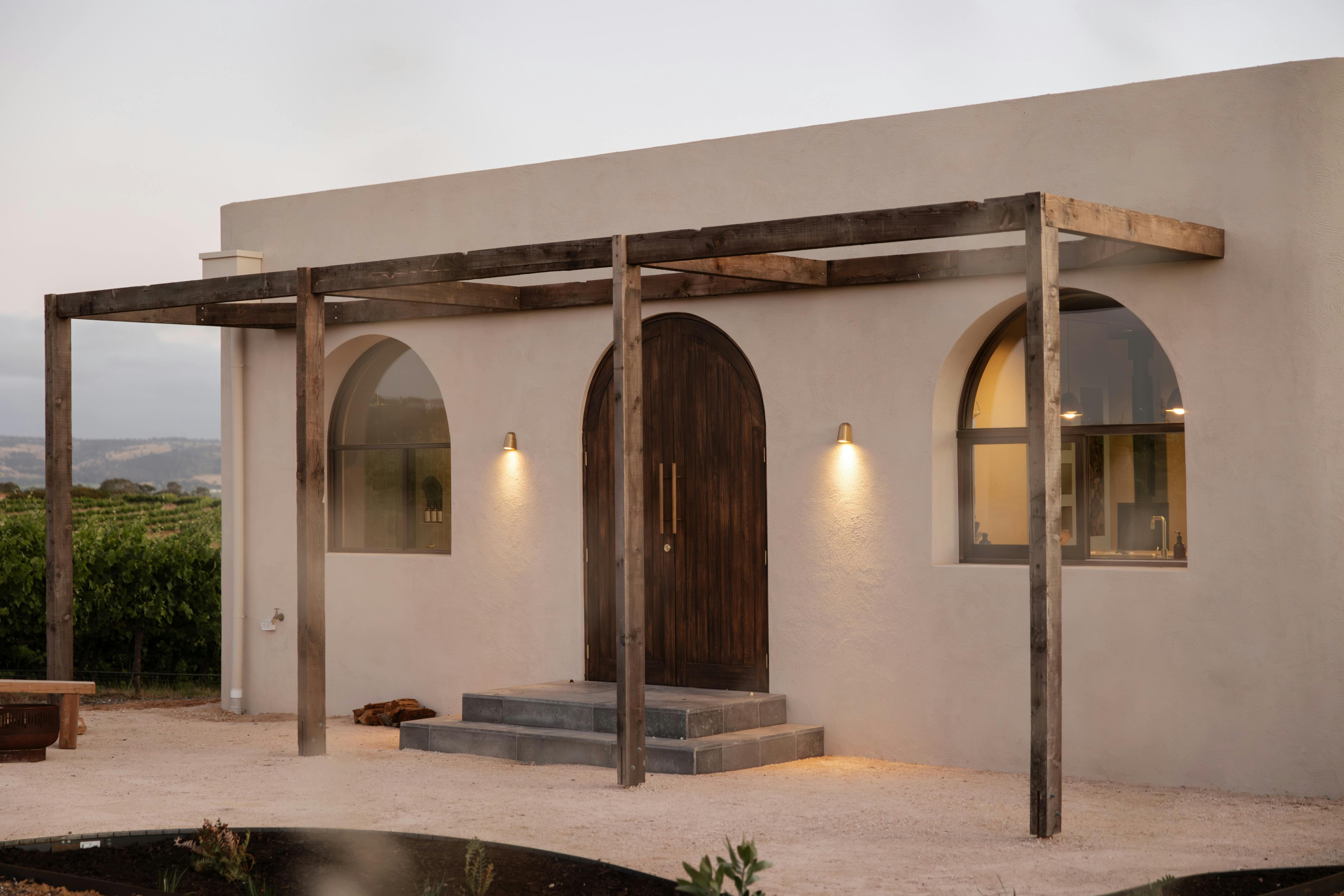 A private courtyard on entrance features a fireplace and reclaimed timber dining setting.