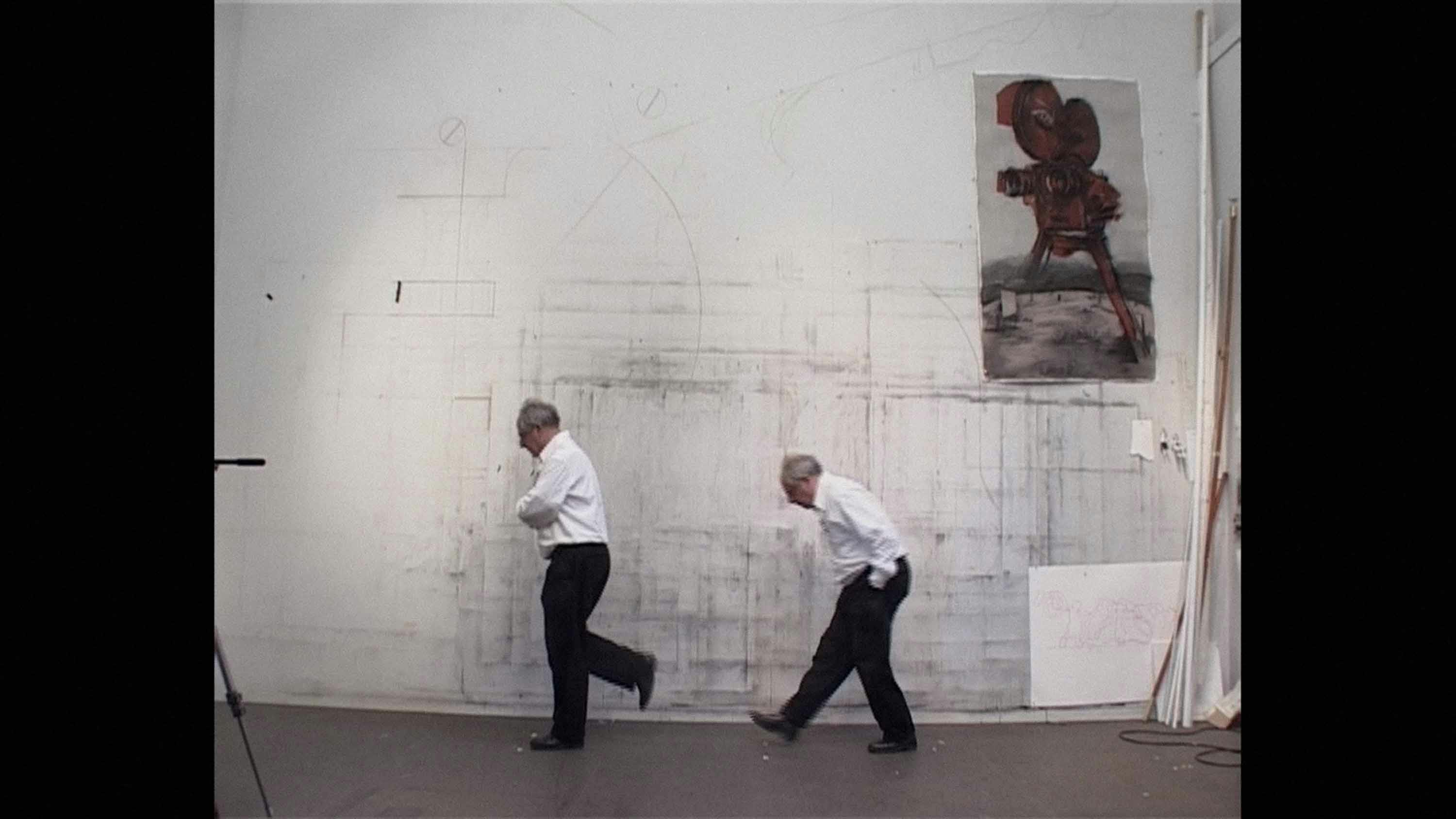 Black and white image of two men drawing on a wall