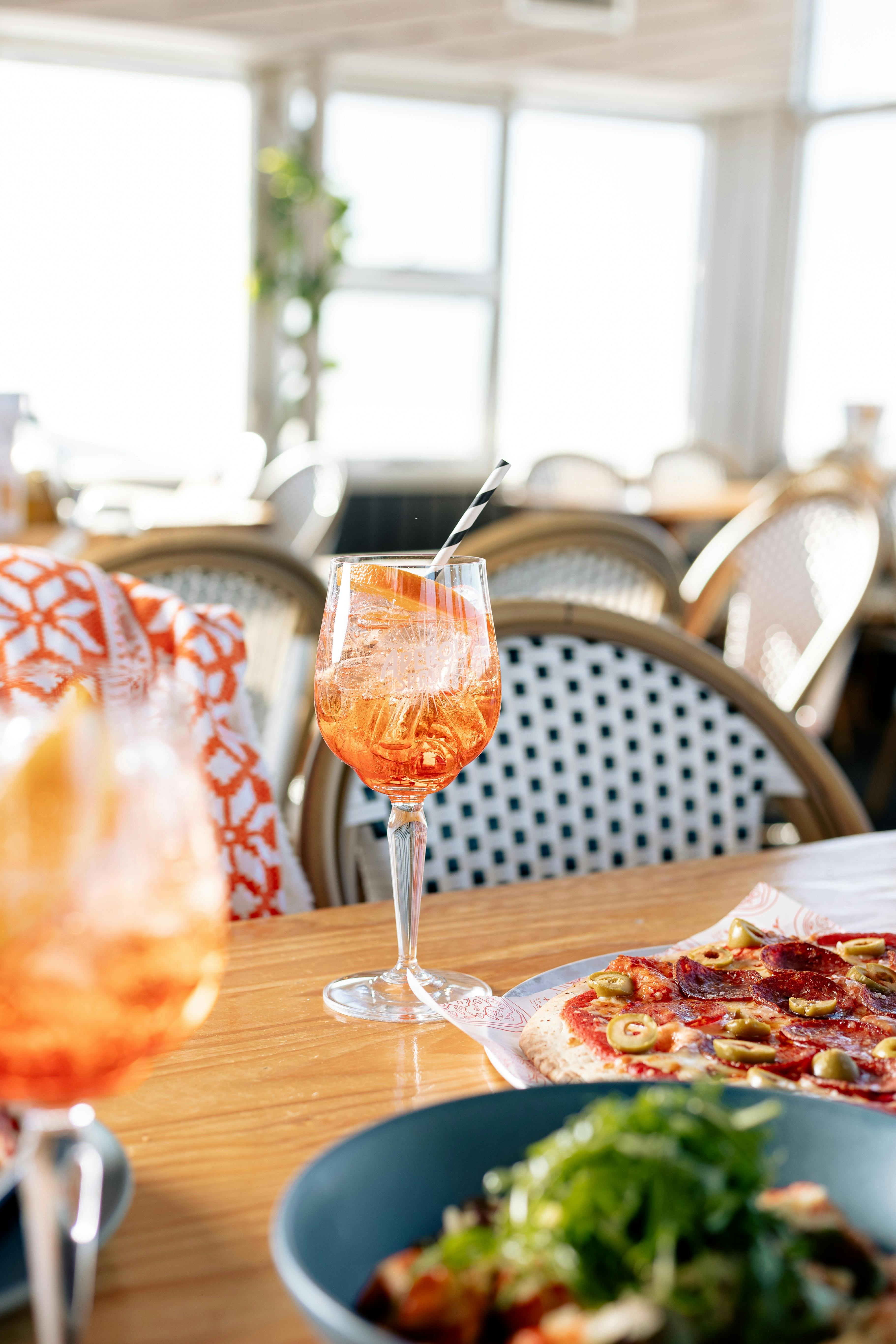 A glass of aperol spritz sitting on a table at eagles nest restaurant