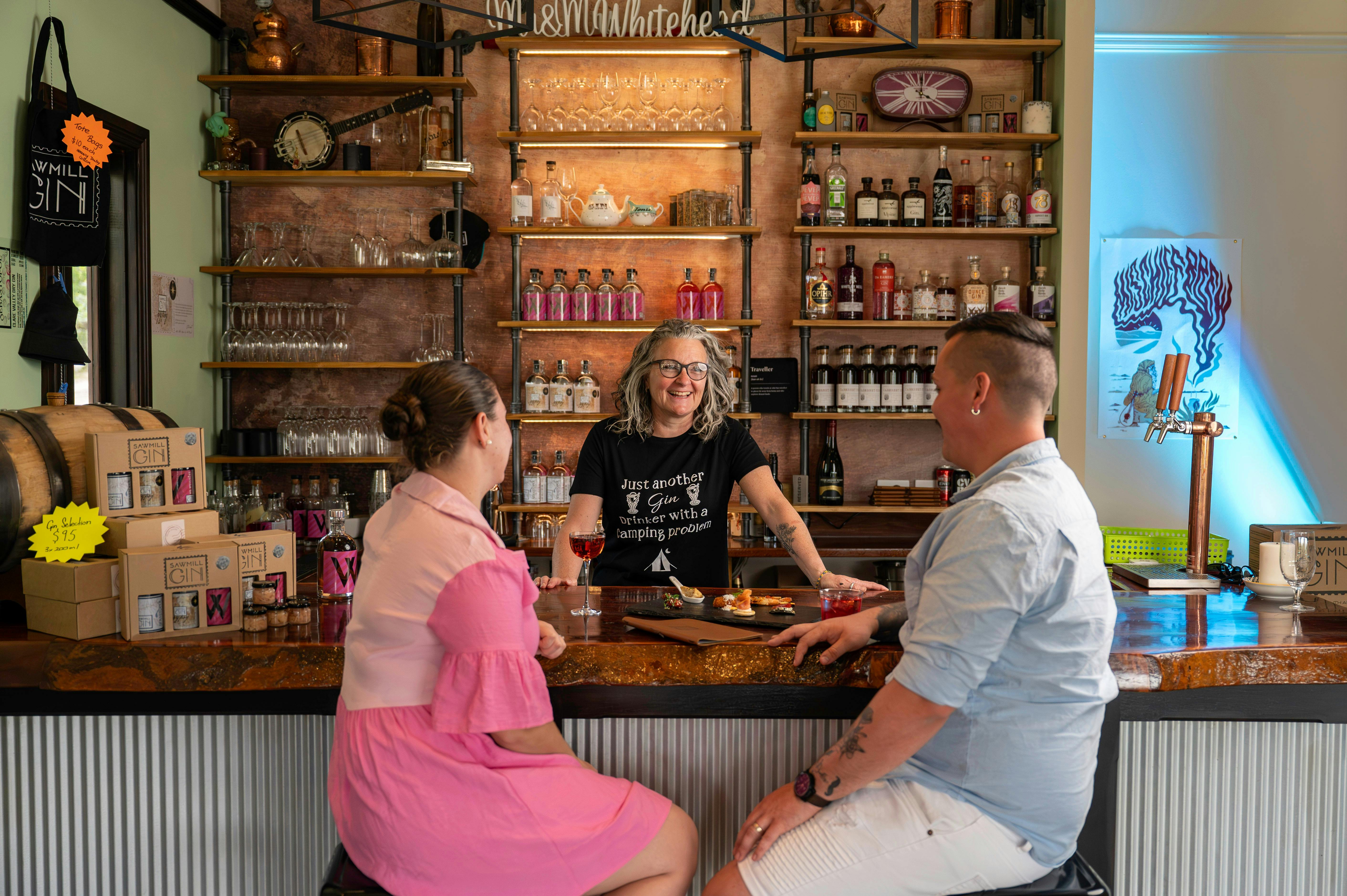 A  couple sit at the bar enjoying a drink and canapés