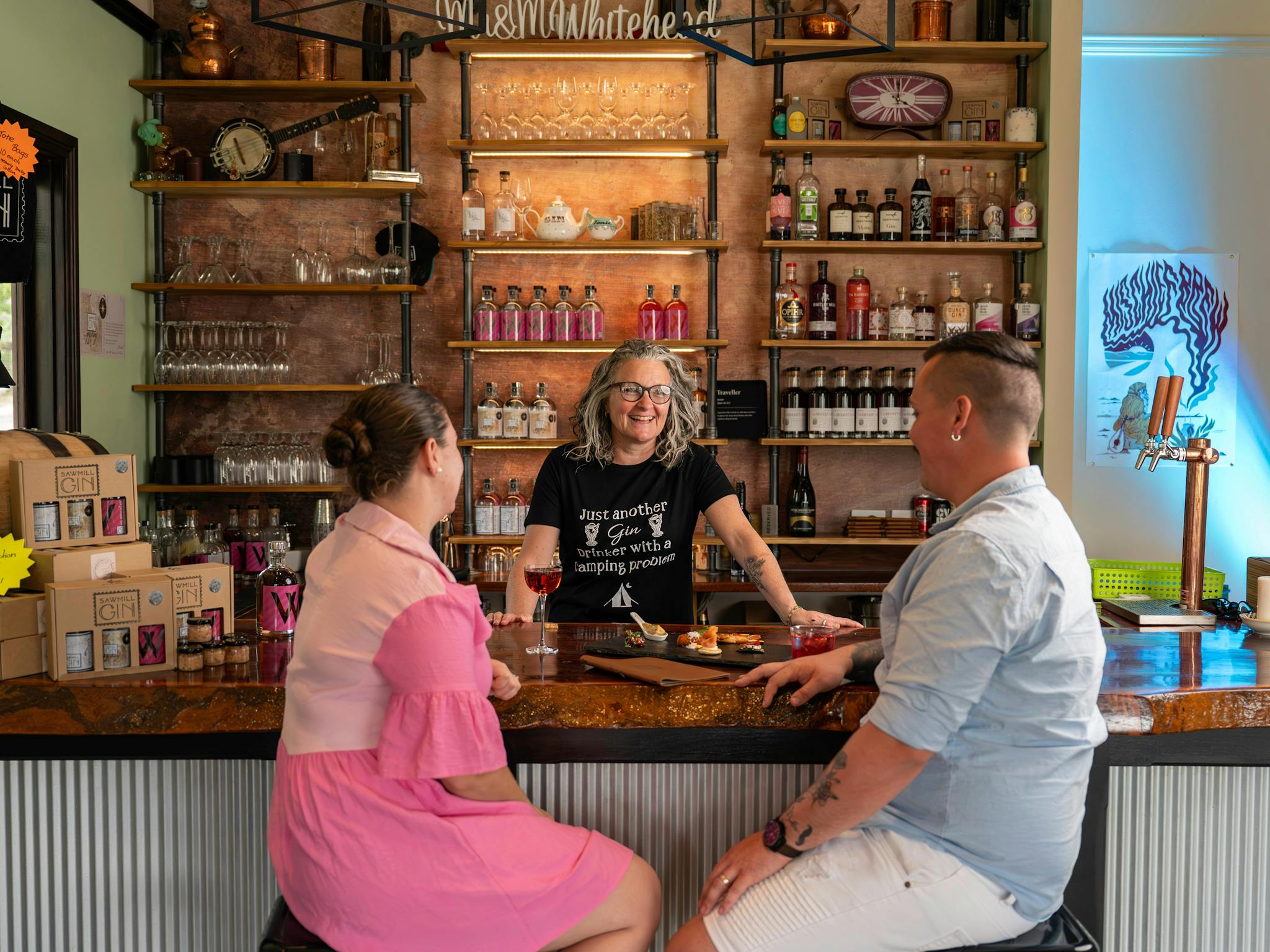A couple sit at the bar enjoying a drink and canapés