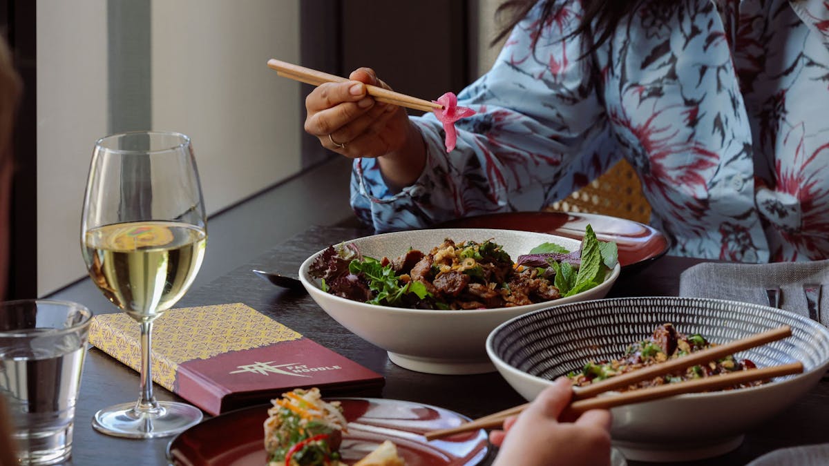 people eating noodle bowls at fat noodle