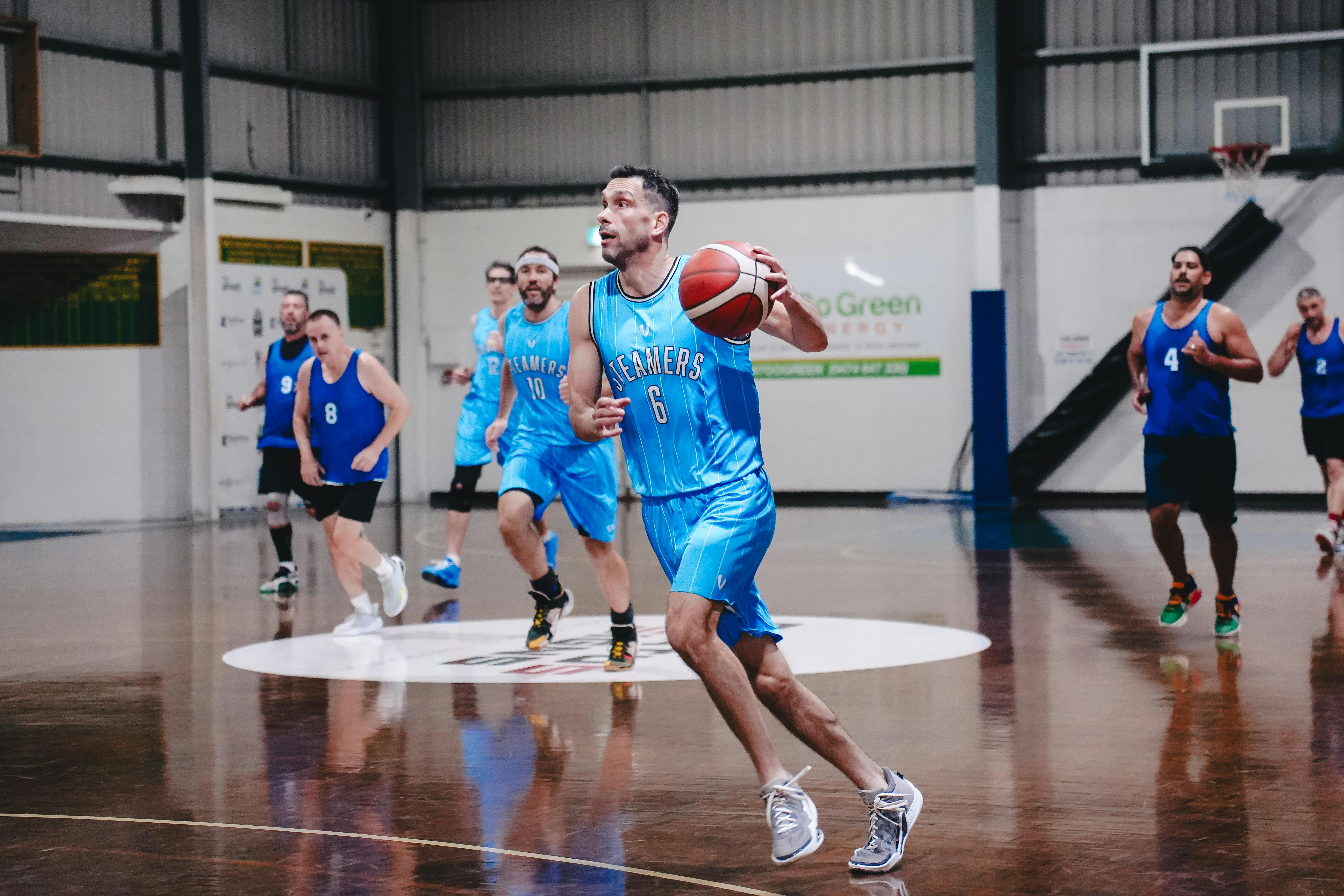 A group of basketball players competes on a court.