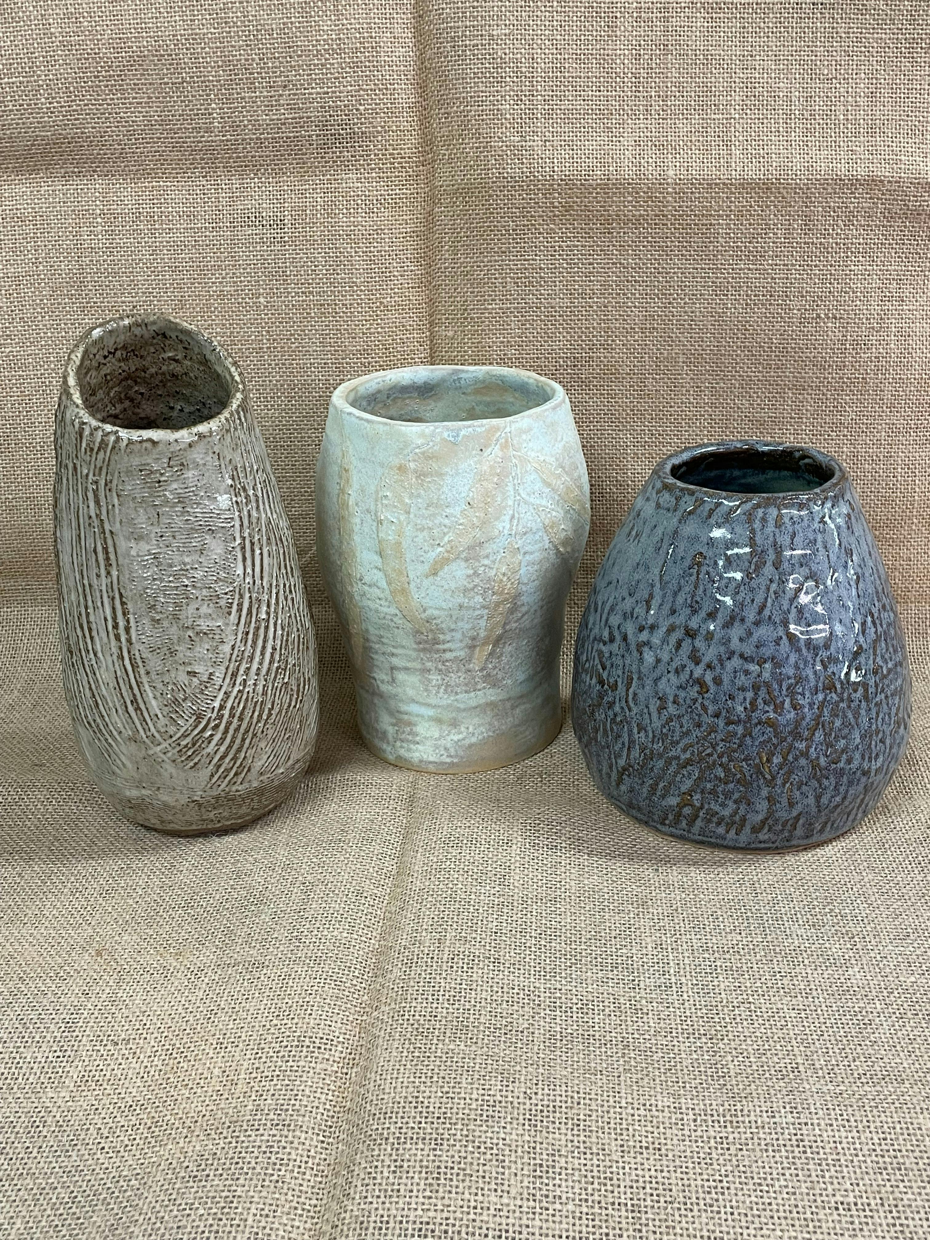 Image shows 3 samples of handbuilt pottery vases on a hessian background
