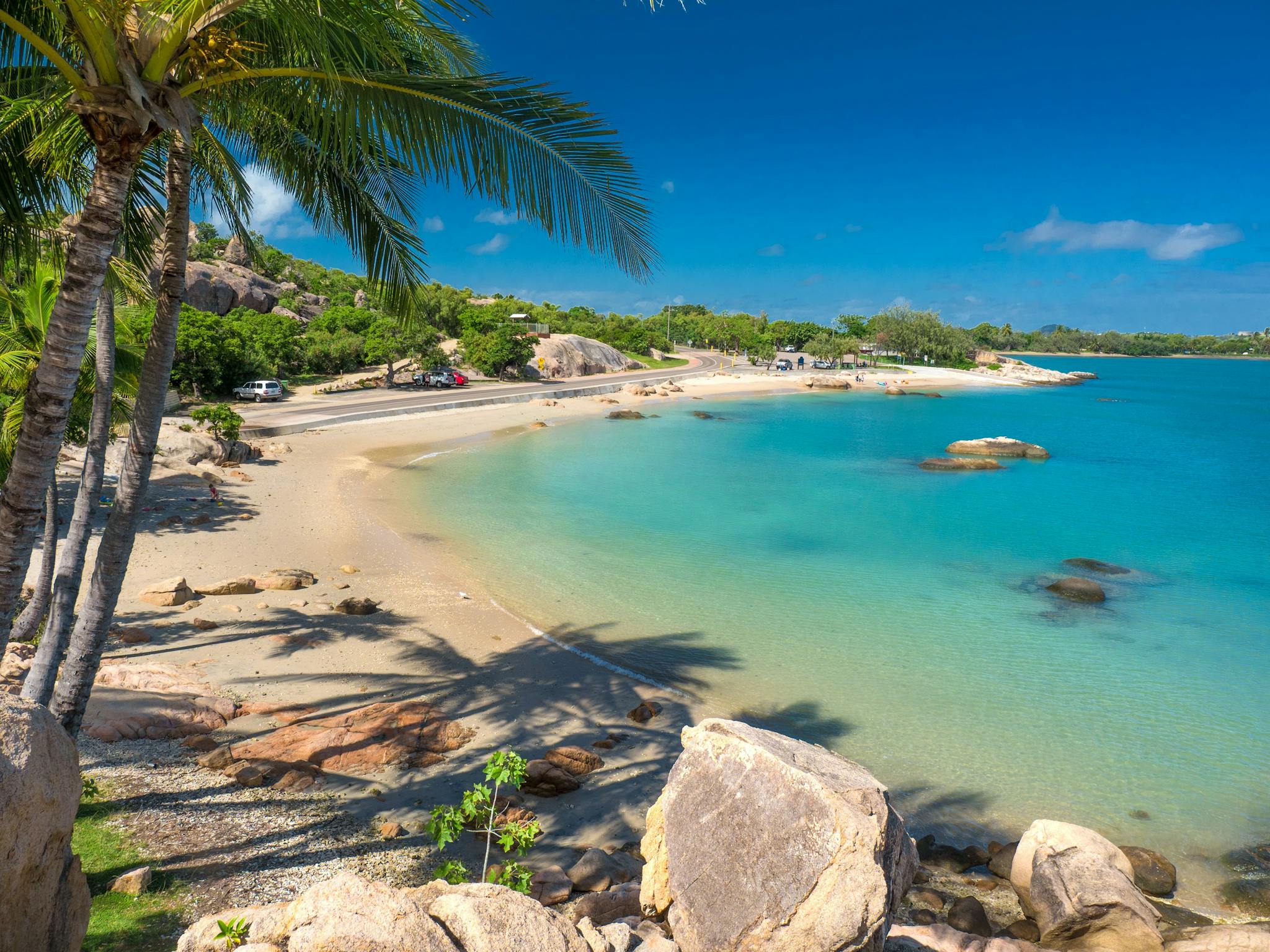 Palm fringed Grays Bay in Bowen with sand and blue water Palm fringed Grays Bay in Bowen with sand and blue water