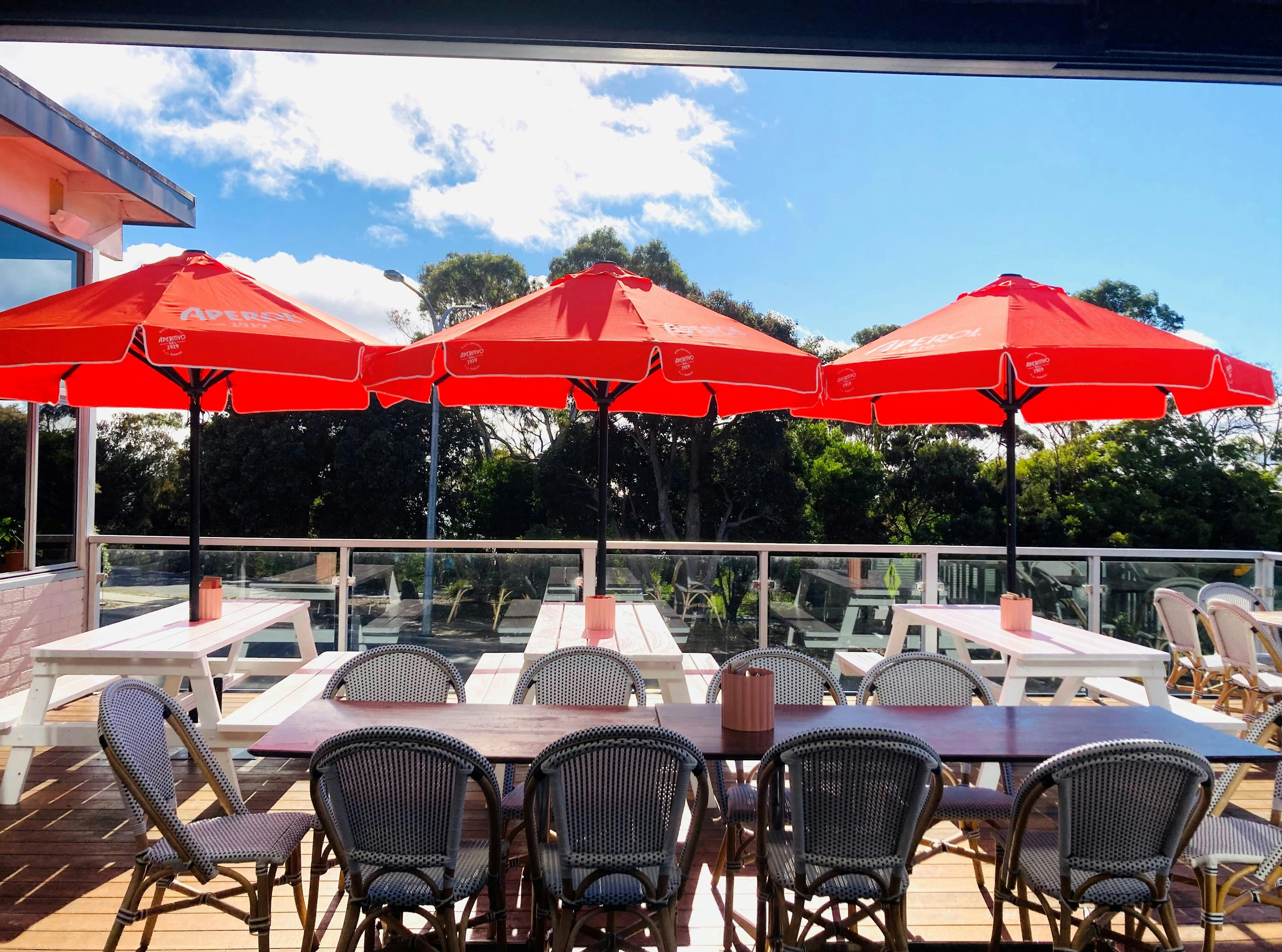 orange umbrealls, tables and chairs on sunny deck