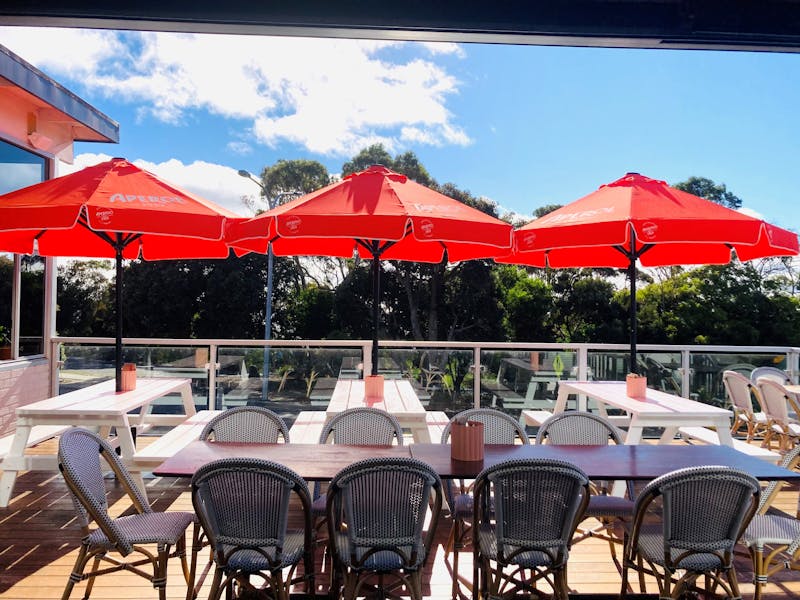 orange umbrealls, tables and chairs on sunny deck