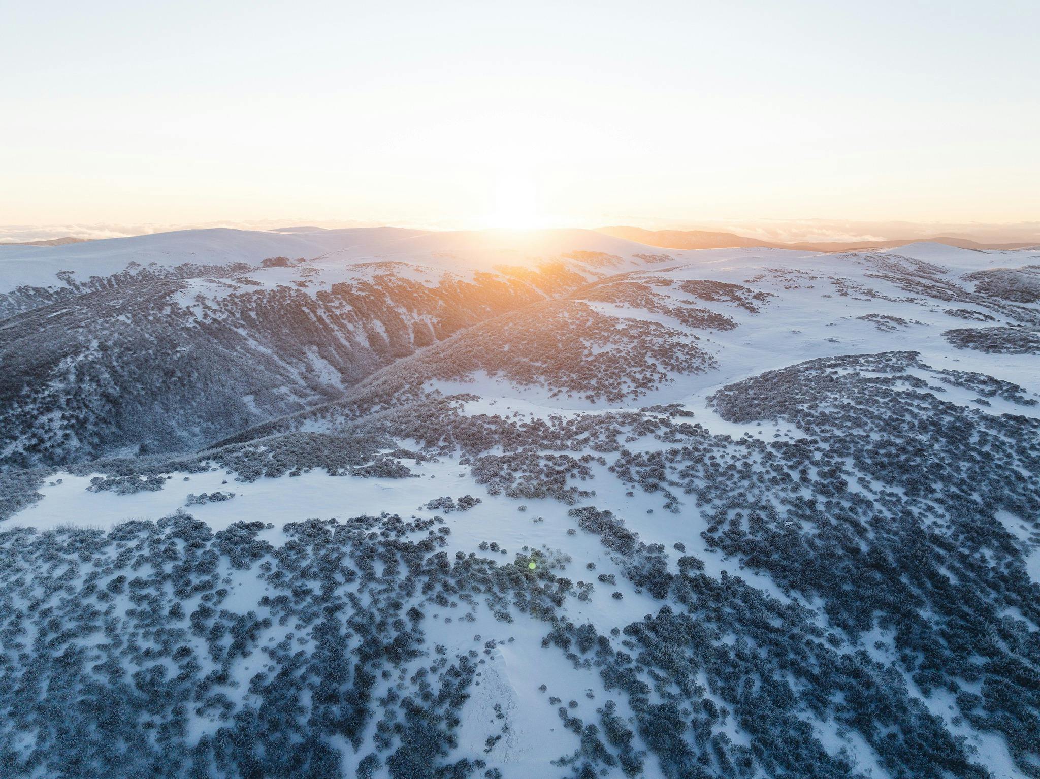 Drone perspective sunrise at Falls creek looking out over the  Bogong High Plains after fresh snow.
