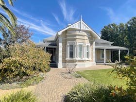 Front facade of Historic Tanunda House with paving and garden in foreground